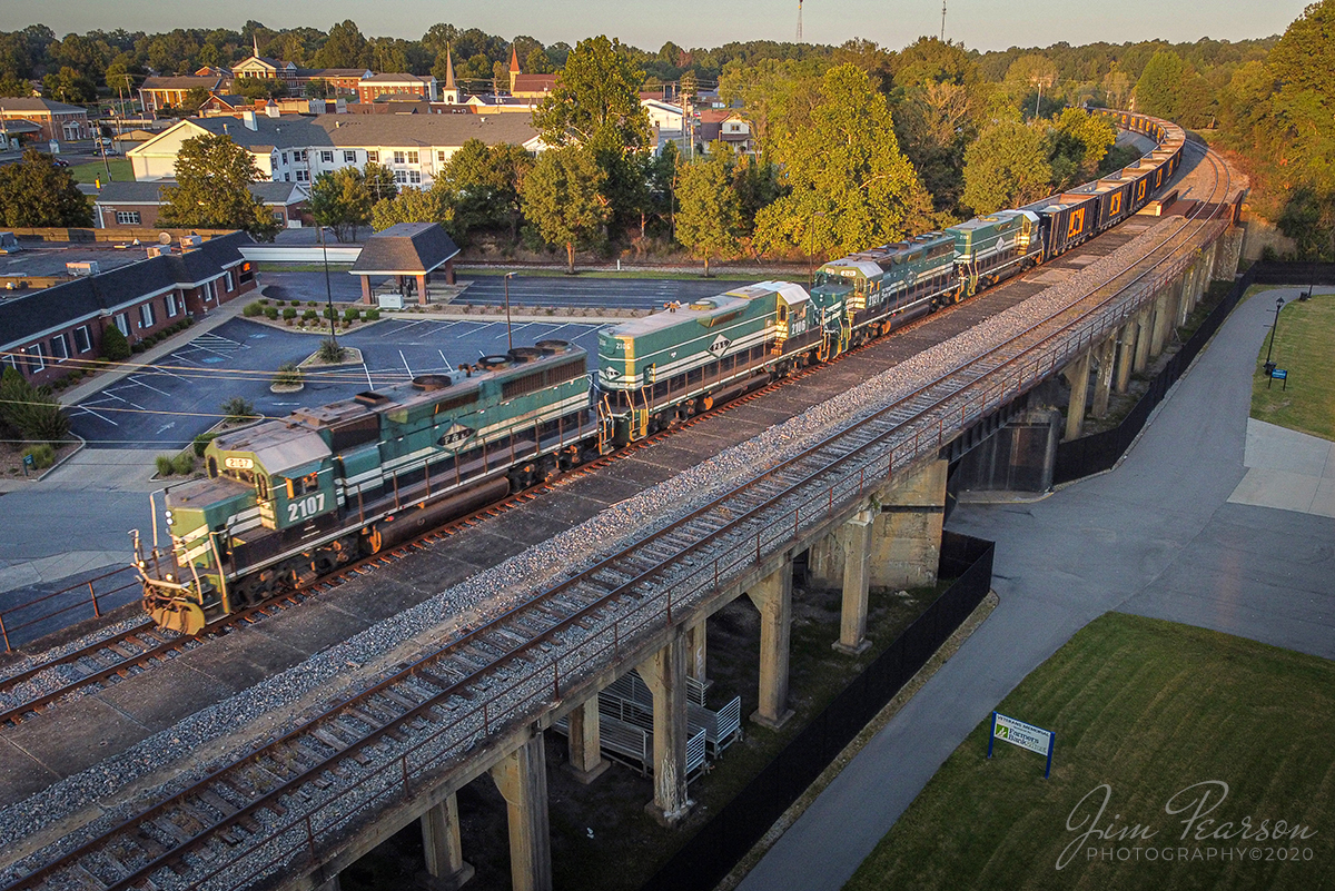 May 13, 2020  Paducah and Louisville Railway (PAL) 2107, leads LV1, a Scottys Rock train, south with PAL 2106, 2121 and 2100 trailing, on the elevated tracks past the location of the old Illinois Central (IC) Depot in Central City, Kentucky, after picking a load of rock cars from Scottys Contracting & Stone at Litchfield, bound for their Madisonville operation.

Around 1920 the IC elevated the mainline through Central City, KY. As part of the project the IC built a new passenger station. The station was a bit unusual, for the actual depot was at street level, and passengers/baggage/freight would take an elevator up to the tracks.

The IC crossed over the L&N's "Owensboro & Nashville" line (where the bridge is in the curve) from Owensboro south to Adairville, KY. The Louisville and Nashville (L&N) passenger trains also used the station until the L&N dropped service on the line in 1941.

The IC discontinued passenger service on the Kentucky Division in 1957. It's suspected the Central City station was demolished soon afterwards. (Thanks to Cliff Downey for the information on the depot!)

Tech Info: DJI Mavic Mini Drone, JPG, 4.5mm (24mm equivalent lens) f/2.8, 1/160, ISO 100.