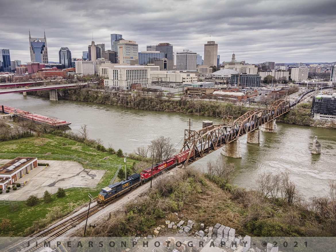 Northbound across the CR Drawbridge on the Cumberland River at Nashville, TN

CSXT 7779, a rebuilt C40-8 and Canadian Pacific 7027, a rebuilt SD70ACU, pull north across the CR Drawbridge as it departs Nashville, Tennessee on the Nashville Terminal Subdivision with empty ethanol train K442 on March 19th, 2021.

I saw for the first time today where this bridge was open for barge traffic on the Cumberland River and I never knew that it is now a swing bridge! I guess at some point in time it was converted, and the name CR Drawbridge was kept. It was built in 1916 by the Louisville and Nashville Railroad and I'm not sure when it was changed to a swing bridge. Perhaps someone out there can provide information on this conversion in the comments!

I did find an interesting video from 2016 where the bridge was rehabilitated by PCL Construction that I'll share in the comments for those that are interested. I'm not sure if this is when it was changed from a draw to a swing bridge or not.

Tech Info: DJI Mavic Air 2 Drone, RAW, 4.5mm (24mm equivalent lens) f/2.8, 1/320, ISO 100.