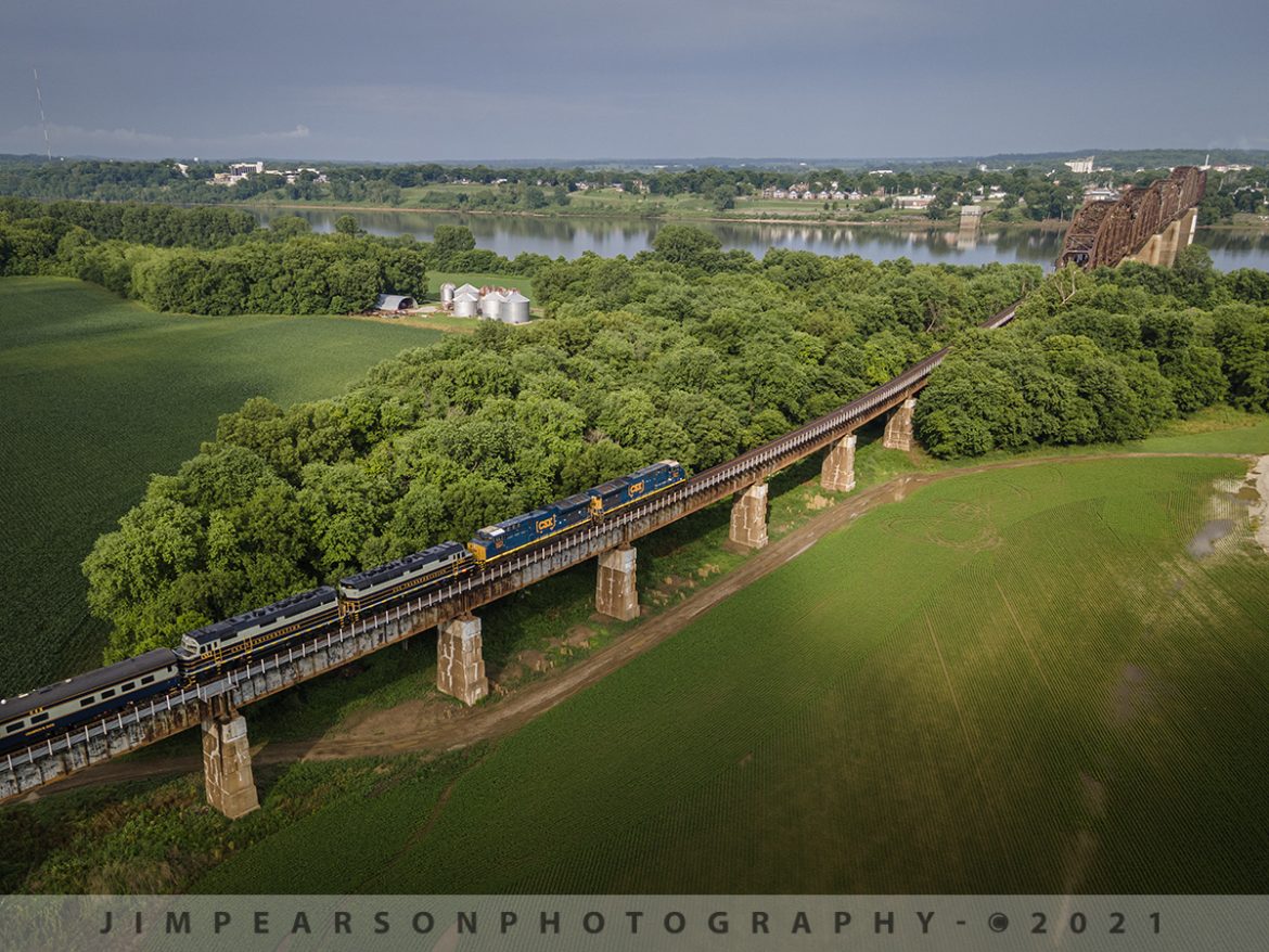 CST P001 heading south on the Henderson Subdivision from Evansville, IN

CSX President's Passenger train P001 heads south up the viaduct as they approach the bridge over the Ohio River to Henderson, Ky from Evansville, IN, with CSX GEVO units 3310, 3271 leading and CSXT 1 & 2 trailing as they pull 11 cars at a little over 1,000 ft long. I heard they had problems with PTC on CSXT 1 & 2 and that's why they GEVOS led the train on June 10th, 2021.

CSX has repainted two of its F40PH locomotives, to be used on this business train, into predecessor Baltimore & Ohio's blue, gray, and black paint scheme. CSX1 is former 9998 (former Amtrak 288) and from what I can find out CSXT 2 is the former F40PH 9993 (former Amtrak 395). The other F40s are expected to be painted in the same scheme in the coming months as they are cycled through the shops.

Tech Info: DJI Mavic Air 2 Drone, RAW, 4.5mm (24mm equivalent lens) f/2.8, 1/500, ISO 100.