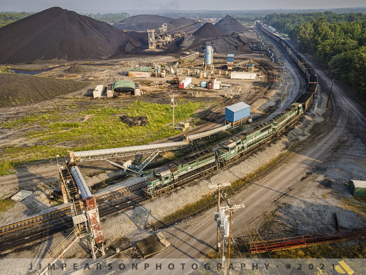Paducah and Louisville Railway PRX1 at Calvert City, Kentucky

Paducah and Louisville Railway 3811, 4504 and 4516 lead loaded coal train PRX1 around the outer loop at the Calvert City Terminal in Calvert City, Kentucky on July 23, 2021, after picking up a load of coal for the TVA Shawnee Power Plant in West Paducah, KY.

According to Wikipedia: "The Paducah & Louisville Railway (reporting mark PAL) is a Class II railroad that operates freight service between Paducah and Louisville, Kentucky. The line is located entirely within the Commonwealth of Kentucky.

The 270-mile (430 km) line was purchased from Illinois Central Gulf Railroad in August 1986. The 223-mile (359 km) main route runs between Paducah and Louisville with branch lines from Paducah to Kevil and Mayfield, Kentucky, and another from Cecilia to Elizabethtown, Kentucky. The PAL interchanges with Burlington Northern Santa Fe (BNSF) and Canadian National (CN), formerly Illinois Central Railroad, in Paducah. In Madisonville, the line interchanges with CSX Transportation (CSXT).

In Louisville, the line interchanges with the Indiana Railroad (INRD), CSX Transportation (CSXT) and Norfolk Southern (NS). Class III line connections are at Princeton with the Fredonia Valley Railroad (FVRR) and at Louisville with the Louisville and Indiana Railroad (LIRC). The line today carries over 200,000 carloads of traffic on a CTC-controlled mainline with welded rail and even a section of multiple main tracks nearly 20 miles (32 km) long between Paducah and just east of Calvert City. This is a huge improvement from the little amount of traffic and poor condition the line was in by the time the ICG had sold it.

Today it is a big regional class II railroad connecting with four class I railroads (listed above), as well as the three shortline connections it makes which are also listed above. It has 270 route-miles of track, of which 233 miles (375 km) are its mainline running between its namesake towns of Paducah and Louisville, as well as branch lines to Mayfield, Kevil, and Elizabethtown. The railroad serves "many chemical plants and other manufacturing companies, several coal mines, numerous clay and stone quarries, lumber and propane distributors, farm [including a few large grain elevators] and mine equipment suppliers, warehouses, transloads, bulk terminals, riverports, and one military base."

The parent company of the PAL, P&L Transportation, also operates the Evansville Western Railway and the Appalachian and Ohio Railroad."

Tech Info: DJI Mavic Air 2 Drone, RAW, 4.5mm (24mm equivalent lens) f/2.8, 1/240, ISO 100.