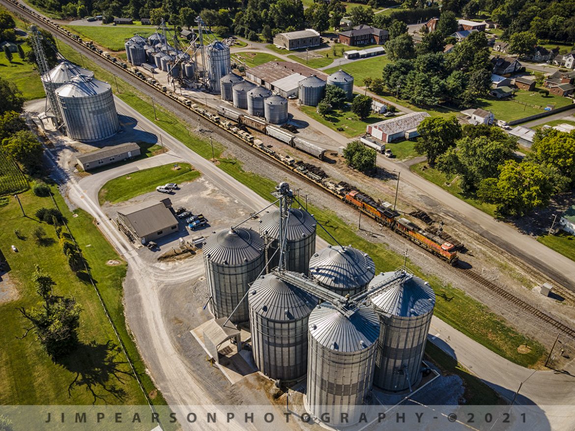 Southbound Military move on the CSX Henderson Subdivision at Trenton, KY

BNSF 5743 and 8363 head up a 7,600ft military train on August 11th, 2021, as it passes through the WF Ware grain operation in downtown Trenton, Kentucky, with CSX W844-03, a third military move heading north to Hopkinsville, KY. At Hopkinsville they backed the train onto the Ft. Campbell wye and Ft. Campbell rail took it on the rest of the way to the base.

For me this photo was as much about the visual look of the grain operation as it was about the military train and that's the reason, I went up a bit higher for this shot than what I normally do. I wanted to show the military cargo trailing off into the distance and could have done so down lower next to the tracks, but I really liked the higher angle, even though you can't see the cargo trailing off into nothing. What do you think? 

Tech Info: Wide Photo: DJI Mavic Air 2 Drone, RAW, 4.5mm (24mm equivalent lens) f/2.8, 1/500, ISO 100.