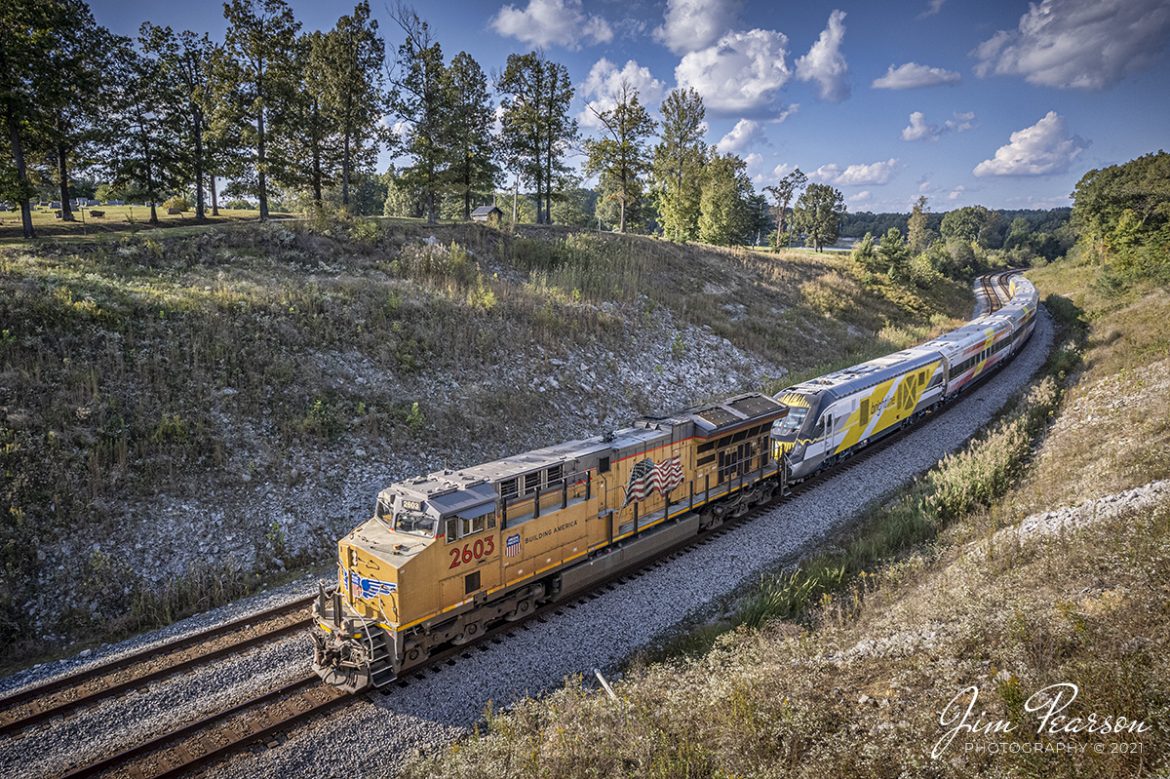 CSX W989 with Union Pacific 2603 leading snakes through the S curve at Nortonville, Kentucky with a brand new Brightline Commuter Trainset as it heads south as on the Henderson Subdivision to Florida on October 8th, 2021.

According to Wikipedia: Brightline is a privately run inter-city rail route between Miami and West Palm Beach, Florida. Brightline began operating over its current route in January 2018 and the company is currently building an extension to the Orlando International Airport which is expected to enter service in 2022.

As of August 2020, it is the only privately owned and operated intercity passenger railroad in the United States. The line was developed starting in March 2012 as All Aboard Florida by Florida East Coast Industries, a Florida real estate developer owned by Fortress Investment Group. Construction began in November 2014 on stations and improvements to tracks owned by the Florida East Coast Railway, which at the start of construction, was also owned by Fortress (it was sold in January 2018).

Tech Info: DJI Mavic Air 2S Drone, RAW, 22mm, f/2.8, 1/1600, ISO 100.

#trainphotography #railroadphotography #trains #railways #dronephotography #trainphotographer #railroadphotographer #jimpearsonphotography