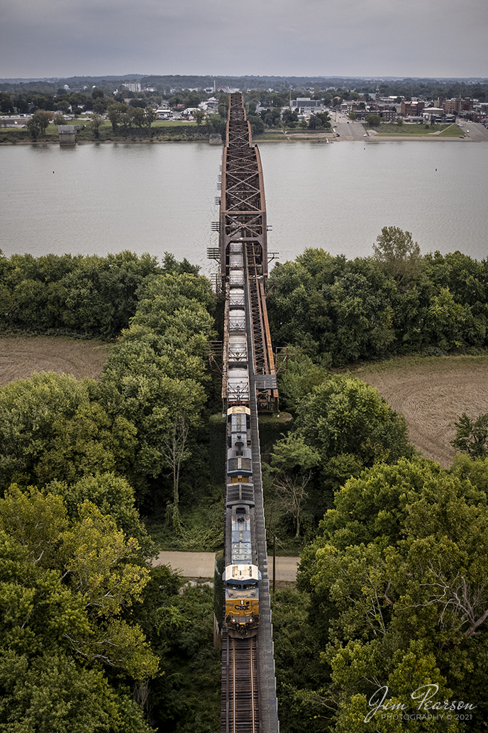 On October 13th, 2021, I spent most of the day trackside with Virtual Railfan Moderator UP Dave, (David Siteman) showing him around some of my favorite spots in Western Kentucky and southern Indiana. We both had a great day trackside, and it was finally great to meet him in person! If youre not already a member, check out Virtual Railfan Live and Virtual Railfan Lounge here on Facebook!

Here we find CSXT 5110 as it leads empty coal train CSX E300-12, a Stilesboro, GA (Plant Bowen) to Effingham, IL (CN) train, across the Ohio River bridge from Henderson, KY on the way north to Evansville, IN on the Henderson Subdivision. This bridge was originally built by the Louisville and Nashville Railroad and was intended to be double tracked eventually, but it never happened.

According to Wikipedia: The Bridge spans the Ohio River between Henderson, Kentucky and Vanderburgh County, Indiana. The bridge is owned by the CSX Transportation.

The original bridge was constructed in 1884 to 1885 by the Louisville and Nashville Railroad at a cost of $2,000,000. The single-tracked bridge was approximately 3,686 feet (1,123 m) long, and its longest span, at 525 feet (160 m), was reputed to be the longest trestle span in the world at that time. The bridge ran from the northern edge of Main Street in Henderson to the low water mark on the Indiana side, resting on 15 stone piers. It was designed to carry two 118,000-pound (54,000 kg) engines followed by 60,000-pound (27,000 kg) coal tenders, and its maximum uniform load capacity was 2,500 pounds per foot (3,700 kg/m). A crowd of 8,000 watched the first train cross the bridge on July 13, 1885.

Prior to the opening of the bridge, railroad passengers and freight had to be transferred to a ferry for the river crossing. The bridge reduced the travel time by several hours.

By 1930 the volume and weight of train traffic were taxing the capabilities of the original bridge. Construction of a new bridge just upstream of the old one began in May 1931. The new bridge, costing over $3,000,000, opened on December 31, 1932. Including its approaches, It is 12,123 feet (3,695 m) long, and its span over the main channel is 648 feet (198 m) long. The demolition of the old bridge, using dynamite, was completed on December 11, 1933.

Tech Info: DJI Mavic Air 2S Drone, RAW, 22mm, f/2.8, 1/1000, ISO 100.

#trainphotography #railroadphotography #trains #railways #dronephotography #trainphotographer #railroadphotographer #jimpearsonphotography