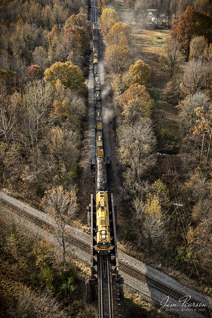 LORAM Railgrinder 401 grinds its way north on the Paducah and Louisville Railway on a beautiful fall afternoon as it crosses over the CSX Henderson Subdivision at Arklow in Madisonville, Kentucky on November 15th, 2021.

According to Wikipedia: A railgrinder (or rail grinder) is a maintenance of way vehicle or train used to restore the profile and remove irregularities from worn tracks to extend its life and to improve the ride of trains using the track. Rail grinders were developed to increase the lifespan of the tracks being serviced for rail corrugation. Rail grinding is a process that is done to stop the deformation due to use and friction on railroad tracks by removing deformations and corrosion. Railroad tracks that experience continual use are more likely to experience corrugation and overall wear. 

Rail grinders are used to grind the tracks when rail corrugation is present, or before corrugation begins to form on the tracks. Major freight train tracks use rail grinders for track maintenance based on the interval of tonnage, rather than time. Transit systems and subways in major cities continue to use scheduled rail grinding processes to combat the corrugation common to heavily used tracks. Rail-grinding equipment may be mounted on a single self-propelled vehicle or on a dedicated rail-grinding train which, when used on an extensive network, may include crew quarters. The grinding wheels, of which there may be more than 100, are set at controlled angles to restore the track to its correct profile.

Tech Info: DJI Mavic Air 2S Drone, RAW, 22mm, f/2.8, 1/500, ISO 100.

#trainphotography #railroadphotography #trains #railways #dronephotography #trainphotographer #railroadphotographer #jimpearsonphotography