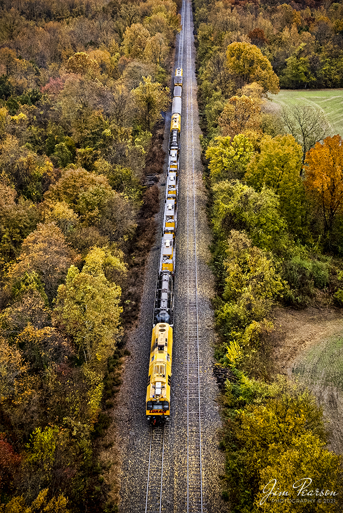 LORAM Railgrinder 401 sits south of Princeton, Kentucky on the Paducah and Louisville Railway on a beautiful fall afternoon on November 11th, 2021.

According to Wikipedia: A railgrinder (or rail grinder) is a maintenance of way vehicle or train used to restore the profile and remove irregularities from worn tracks to extend its life and to improve the ride of trains using the track. Rail grinders were developed to increase the lifespan of the tracks being serviced for rail corrugation. Rail grinding is a process that is done to stop the deformation due to use and friction on railroad tracks by removing deformations and corrosion. Railroad tracks that experience continual use are more likely to experience corrugation and overall wear. 

Rail grinders are used to grind the tracks when rail corrugation is present, or before corrugation begins to form on the tracks. Major freight train tracks use rail grinders for track maintenance based on the interval of tonnage, rather than time. Transit systems and subways in major cities continue to use scheduled rail grinding processes to combat the corrugation common to heavily used tracks. Rail-grinding equipment may be mounted on a single self-propelled vehicle or on a dedicated rail-grinding train which, when used on an extensive network, may include crew quarters. The grinding wheels, of which there may be more than 100, are set at controlled angles to restore the track to its correct profile.

Tech Info: DJI Mavic Air 2S Drone, RAW, 22mm, f/2.8, 1/320, ISO 140.