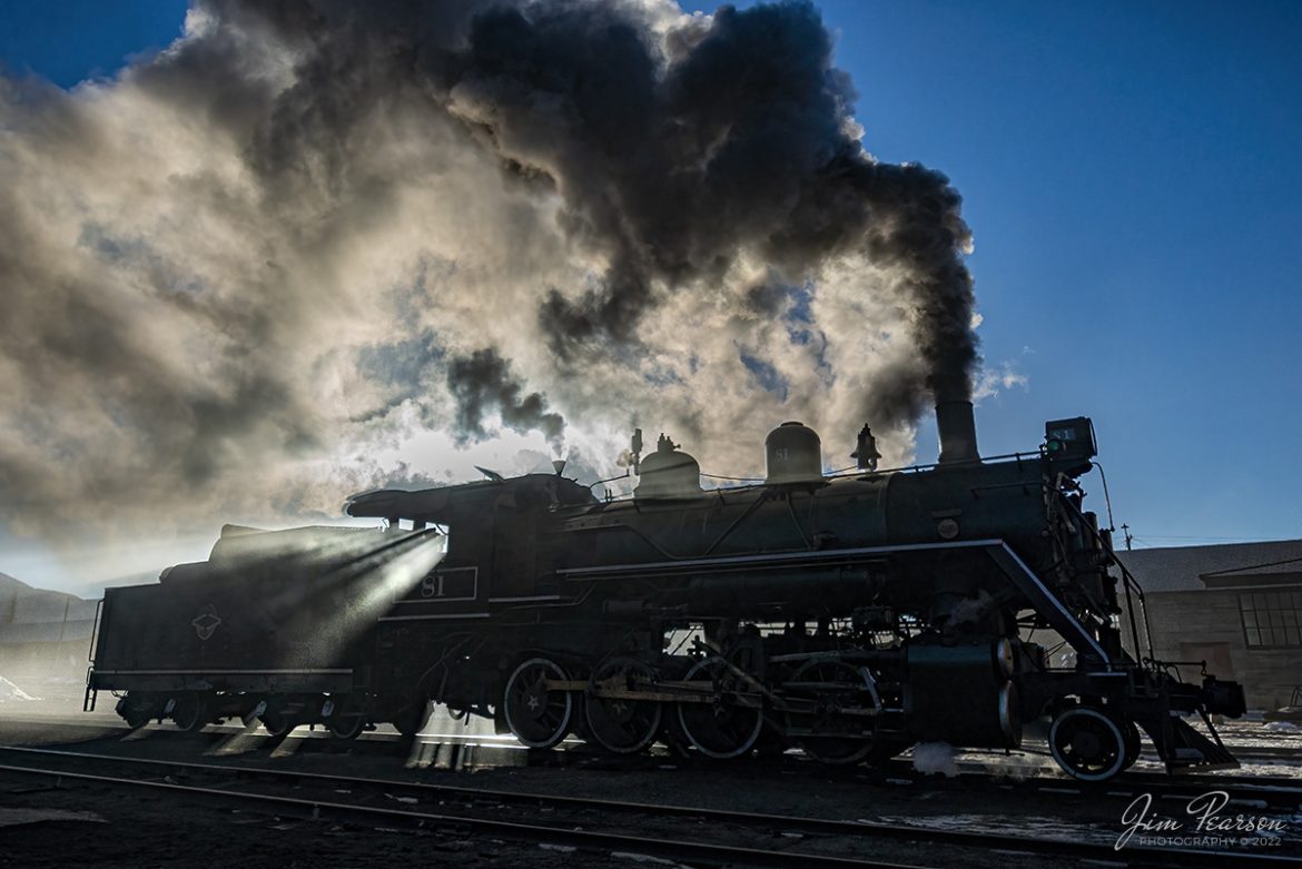 The frigid early morning air and backlight sunlight makes for a dramatic photo with streams of sunlight passing through the steam, as Nevada Northern Railway engine 81 sits outside of the engine house as the crew gets it ready for another day at Ely, Nevada on February 13th, 2022. 

Nevada Northern No. 81 is a "Consolidation" type (2-8-0) steam locomotive that was built for the Nevada Northern in 1917 by the Baldwin Locomotive Works in Philadelphia, PA, at a cost of $23,700. It was built for Mixed service to haul both freight and passenger trains on the Nevada Northern railway.

According to Wikipedia: "The Nevada Northern Railway Museum is a railroad museum and heritage railroad located in Ely, Nevada and operated by a historic foundation dedicated to the preservation of the Nevada Northern Railway."

Tech Info: Nikon D800, RAW, Nikon 10-24mm @ 14mm, f/4, 1/8000, ISO 500.

#trainphotography #railroadphotography #trains #railways #jimpearsonphotography #trainphotographer #railroadphotographer #steamtrains #nevadanorthernrailway