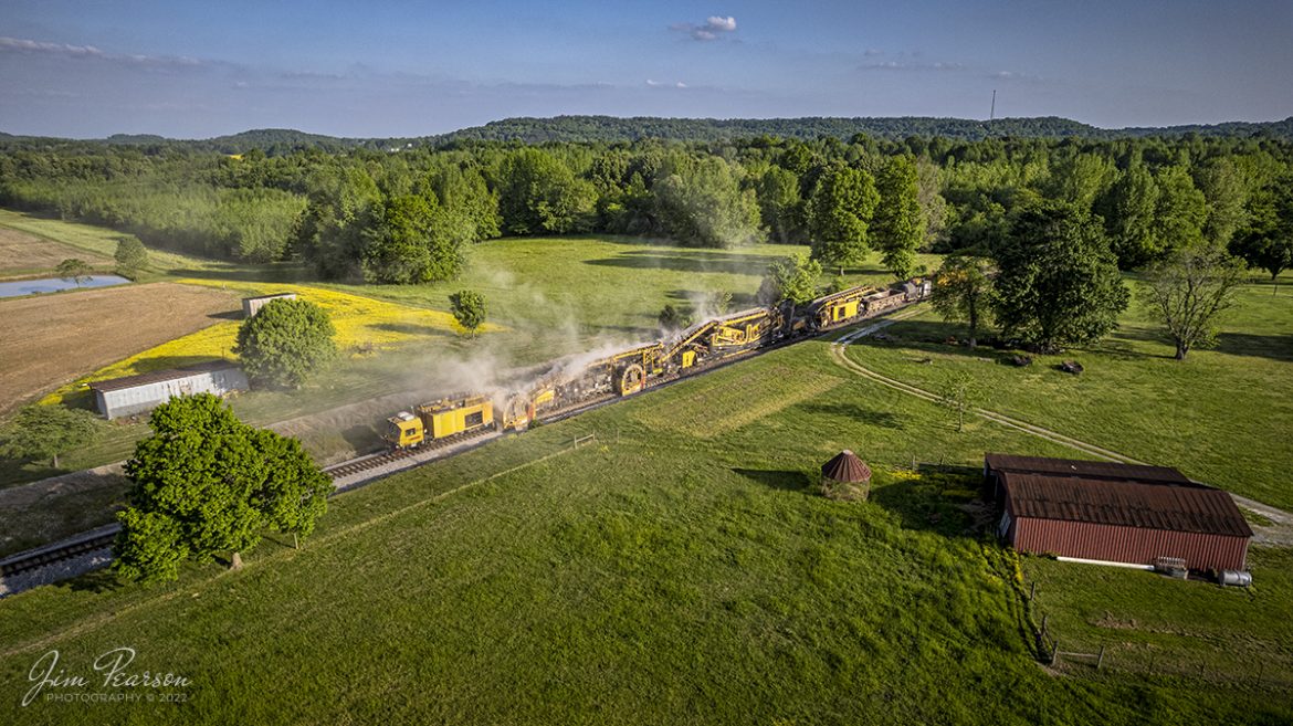 LoRam shoulder ballast cleaner SBC-2401 makes its way north on the CSX Henderson Cuttoff through the beautiful spring countryside of Mortons Gap, Kentucky on May 10th, 2022, as it moves slowly along cleaning the ballast on both sides of the rails.

Shoulder ballast cleaning consists of removing ballast at the end of the ties, screening the ballast and discarding fines and fouling material and restoring the good ballast to the shoulder. Integrated scarifiers break open end of tie mud pockets, removes fines, and restores ballast voids in the shoulders and under the tie ends and release damaging trapped water.

Tech Info: DJI Mavic Air 2S Drone, RAW, 22mm, f/2.8, 1/1250, ISO 100.

#trainphotography #railroadphotography #trains #railways #dronephotography #trainphotographer #railroadphotographer #jimpearsonphotography