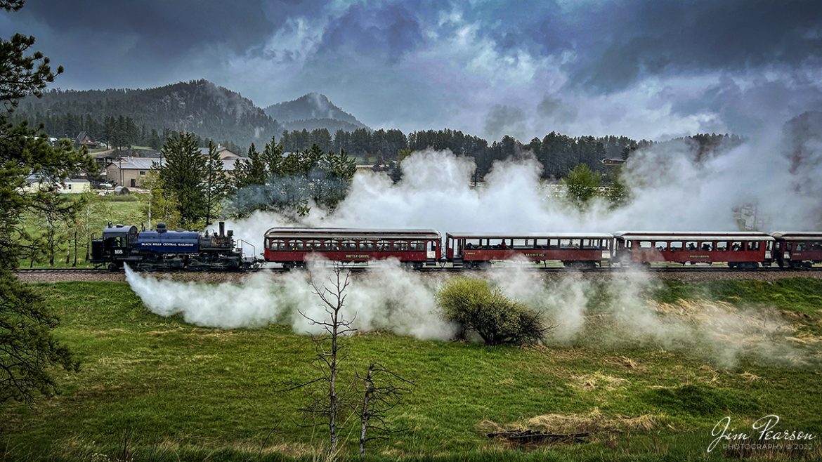 The 1880 Train, Black Hills Central Railroad locomotive crew on 108 performs a blow down on the engine as they arrive back at Hill City, SD on May 30th, 2022, under stormy skies. 

A Blowdown, where the left and right blow down cocks, located at the lowest portion of the firebox sides (mud ring), are opened to blow out mineral sediments in the boiler water. Addition of various chemicals in the tender water is designed to keep the sediments (mud, etc.) from sticking to the internal steel components of the firebox/boiler. On a regular basis, those "settled" sediments need to blown out at safe locations on the railroad. Thus, the locomotives are being "blown down".

According to their website: Locomotive #108 joined its nearly identical twin, #110, at the beginning of the 2020 season following a four-year restoration. It is a 2-6-6-2T articulated tank engine that was built by the Baldwin Locomotives Works in 1926 for the Potlatch Lumber Company. It later made its way to Weyerhaeuser Timber Company and eventually to the Northwest Railway Museum in Snoqualmie, Washington.

The acquisition and subsequent restoration of locomotive #108 completed a more than 20-year goal of increasing passenger capacity which began with the restoration of #110 and the restoration of multiple passenger cars. Both large Mallet locomotives (pronounced Malley) can pull a full train of seven authentically restored passenger cars, up from the four cars utilized prior to their addition to the roster.

Tech Info: iPhone 13 Pro Max, 5.7mm, f/1.5, 1/1147, ISO 50.

#trainphotography #railroadphotography #trains #railways #jimpearsonphotography #trainphotographer #railroadphotographer #blackhillscentralrailroad #STEAM #steamtrains