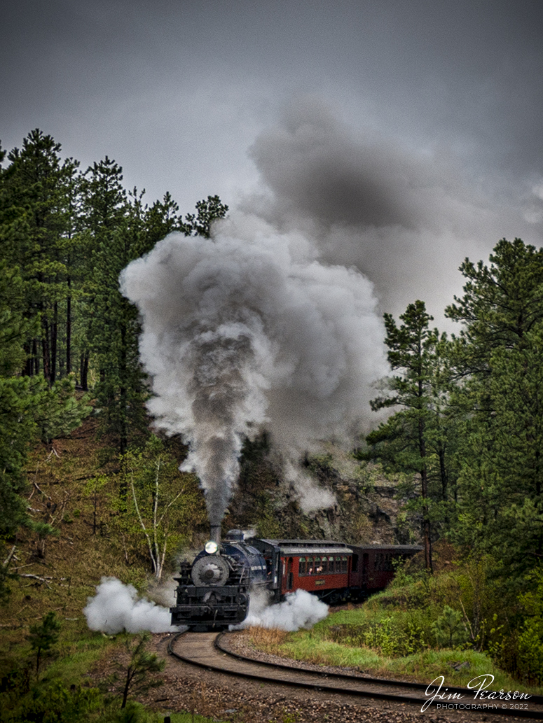 The Black Hills Central Railway locomotive 108 rounds a curve as it heads through the countryside as it makes its first trip of the day in stormy, wet weather of the forest to Keystone, South Dakota on my birthday, May 30th, 2022! I for one cant recall a better way to spend the day then chasing a steam locomotive and they later in the day riding it with family! Despite the wet and rainy weather, it was a great day, and I even got the drone up a few times! 

According to their website: Locomotive #108 joined its nearly identical twin, #110, at the beginning of the 2020 season following a four-year restoration. It is a 2-6-6-2T articulated tank engine that was built by the Baldwin Locomotives Works in 1926 for the Potlatch Lumber Company. It later made its way to Weyerhaeuser Timber Company and eventually to the Northwest Railway Museum in Snoqualmie, Washington.

The acquisition and subsequent restoration of locomotive #108 completed a more than 20-year goal of increasing passenger capacity which began with the restoration of #110 and the restoration of multiple passenger cars. Both large Mallet locomotives (pronounced Malley) can pull a full train of seven authentically restored passenger cars, up from the four cars utilized prior to their addition to the roster.

Tech Info: Nikon D800, RAW, Nikon 10-24mm @ 16mm, f/4, 1/400, ISO 180.

#trainphotography #railroadphotography #trains #railways #jimpearsonphotography #trainphotographer #railroadphotographer