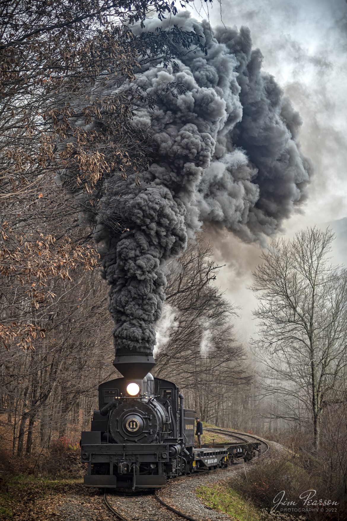 Cass Scenic Railway Shay locomotive number 11, (C-90-3) climbs uphill through a S curve in forest during the Rail Heritage Photography Weekend photo shoot at Cass, West Virginia on November 5th, 2022. 

According to Wikipedia: Cass Scenic Railroad, is an 11-mile (18 km) long heritage railway owned by the West Virginia State Rail Authority and operated by the Durbin and Greenbrier Valley Railroad. The park also includes the former company town of Cass and a portion of the summit of Bald Knob, the highest point on Back Allegheny Mountain.

Founded in 1901 by the West Virginia Pulp and Paper Company (now WestRock), Cass was built as a company town to serve the needs of the men who worked in the nearby mountains cutting spruce and hemlock for the West Virginia Spruce Lumber Company, a subsidiary of WVP&P. At one time, the sawmill at Cass was the largest double-band sawmill in the world. It processed an estimated 1.25 billion board feet (104,000,000 cu ft; 2,950,000 m3) of lumber during its lifetime. In 1901 work started on the 4 ft 8+1⁄2 in (1,435 mm) standard gauge railroad, which climbs Back Allegheny Mountain. 

The railroad eventually reached a meadow area, now known as Whittaker Station, where a logging camp was established for the immigrants who were building the railroad. The railroad soon reached the top of Gobblers Knob, and then a location on top of the mountain known as 'Spruce'. The railroad built a small town at that location, complete with a company store, houses, a hotel, and a doctor's office. Work soon commenced on logging the red spruce trees, which grew in the higher elevations.

Tech Info: DJI Mavic Air 2S Drone, 22mm, f/2.8, 1/1250, ISO 140.

#trainphotography #railroadphotography #trains #railways #dronephotography #trainphotographer #railroadphotographer #jimpearsonphotography #cassscenicrailway #steamtrains