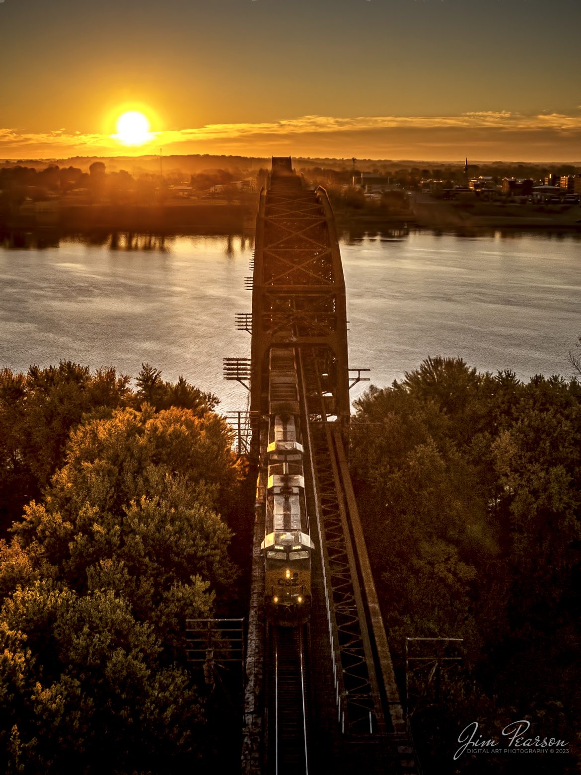CSXT 845 leads E302 northbound as it exits the bridge over the Ohio River at sunrise, from Henderson, Kentucky, on October 28th, 2022, on the Henderson Subdivision. This train runs between Stilesboro, GA (Plant Bowen) and Sugar Camp Mine on the Evansville Western Railway.

Tech Info: DJI Mavic Air 2S Drone, RAW, 22mm, f/2.8, 1/2000, ISO 100 -1.7stops.

#trainphotography #railroadphotography #trains #railways #dronephotography #trainphotographer #railroadphotographer #jimpearsonphotography