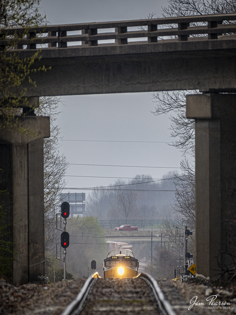 The nose of CSXT 3154 peeks over the rise as CSX I025 passes through the Hospital Drive crossing, approaching the Main Street overpass at Madisonville, Ky, on March 24th, 2023, on the Henderson Subdivision. This image was made as the train was about one half mile away from where I was standing, with a 440mm lens. The compression from the lens makes the train look much closer than what it was.

Tech Info: Nikon D800, RAW, Sigma 150-600mm @ 440mm, f/6, 1/1000, ISO 800.

#trainphotography #railroadphotography #trains #railways #jimpearsonphotography #trainphotographer #railroadphotographer