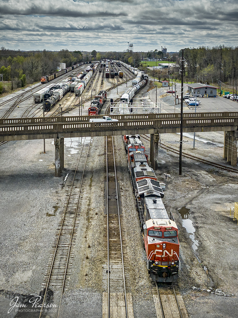 Canadian National 3270 leads a mixed freight as it snakes its way out of the yard at Fulton, Ky after a crew change, as they head north up the CN Cairo Subdivision, on March 25th, 2023. 

Im told that on average 40-60 trains a day pass through Fulton, Ky, making it a busy place! Railfanning is best in the morning and the afternoon into the evening. The CN Cairo, CN Fulton Subdivisions and the West Tennessee Railroad all come together here at Fulton. Also, Amtrak has a depot here and is a flag stop for the City of New Orleans, and is an unstaffed station; with no agent and no assistance.

The first railroad deed was sold in 1857, and construction reached Pontotoc in 1859. At that time Fulton was referred to as the end of the line by the United States Government and all mail was addressed to this extent. In 1896, the Illinois Central Railroad owned the two railroad lines that crossed Fulton, which saw 30 passenger trains a day and 3,000 freight cars that picked up or delivered cargo. The freight cars would usually have bananas that would stop in Fulton to be re-iced and then shipped to rest of the country. Through this process, Fulton became known as the "Banana Capital of the World".

Tech Info: DJI Mavic 3 Classic Drone, RAW, 24mm, f/2.8, 1/3200, ISO 220.

#trainphotography #railroadphotography #trains #railways #dronephotography #trainphotographer #railroadphotographer #jimpearsonphotography #kentuckytrains #csx #csxrailway #FultonKy #mavic3classic #drones #trainsfromtheair #trainsfromadrone