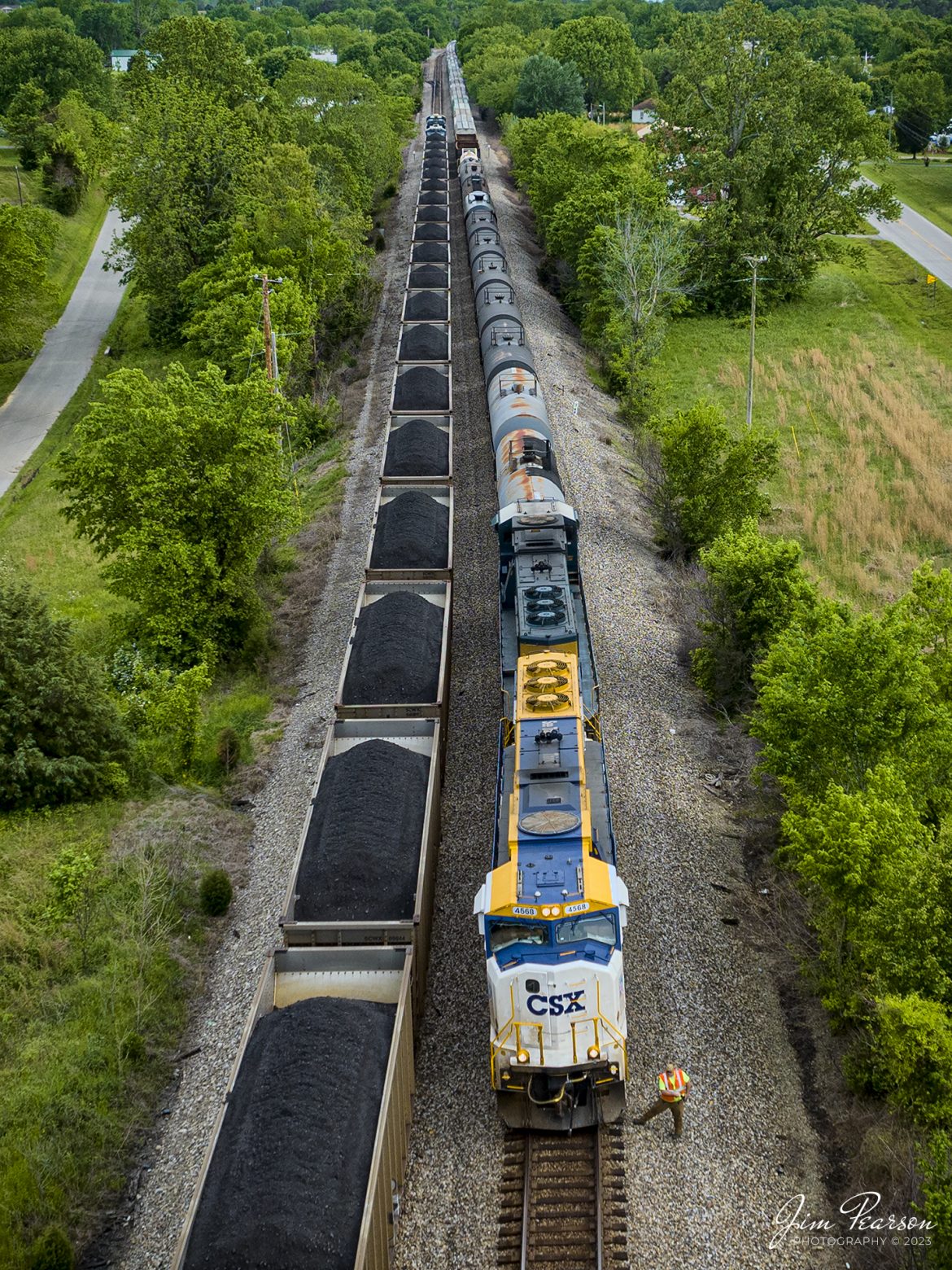 The conductor on CSXT G412, 50th Anniversary of Operation Lifesaver locomotive 4568, does a roll by inspection of loaded coal train, C904 as it pulls into the north end of the siding at Kelly, Kentucky on May 10th, 2023, on the Henderson Subdivision.

CSX C904 pulled all the way into the siding to allow the southbound local, L391, to pull in behind him so G412 could continue its move north.

Tech Info: DJI Mavic 3 Classic Drone, RAW, 24mm, f/2.8, 1/1000, ISO 140.

#trainphotography #railroadphotography #trains #railways #dronephotography #trainphotographer #railroadphotographer #jimpearsonphotography #BNSFtrains #mavic3classic #drones #trainsfromtheair #trainsfromadrone #coaltrain #CSXT #CalvertCityKy #CSXHonoringLawEnforcement