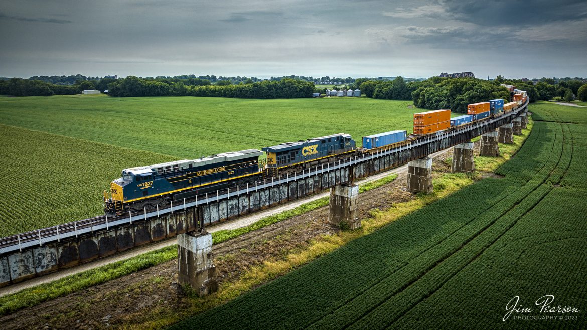 The new CSX Heritage series locomotive, the Baltimore & Ohio unit 1827, leads CSX hot intermodal I028 as it down the viaduct at Rahm, Indiana after crossing the Ohio River at Henderson, Ky, on its northbound move up the Henderson Subdivision, on July 17th, 2023.

According to Wikipedia: The Baltimore and Ohio Railroad was the first common carrier railroad and the oldest railroad in the United States with its first section opening in 1830.

The Chesapeake and Ohio Railway took financial control of the B&O in 1963.[52] On May 1, 1971, Amtrak had taken over all the remaining non-commuter routes of the B&O. The B&O already had a controlling interest in the Western Maryland Railway. In 1973 the three railroads were brought together under one corporate identity, the Chessie System, although they continued to operate as separate railroads. 

In 1980 the Chessie System and Seaboard Coast Line Industries, a holding company that owned the Seaboard Coast Line, the Louisville & Nashville, the Clinchfield, and the Georgia Railroad, agreed to form CSX Corporation. SCL Industries was renamed the Seaboard System Railroad (SBD) in 1983, the same year that the Western Maryland Railway was completely absorbed into the B&O. SBD was renamed CSX Transportation (CSX) in 1986. On April 30, 1987, the B&O's corporate existence ended when it was absorbed into the Chesapeake and Ohio Railway, which merged into CSX Transportation on August 31 of that year.

Tech Info: DJI Mavic 3 Classic Drone, RAW, 24mm, f/2.8, 1/2000, ISO 270.

#trainphotography #railroadphotography #trains #railways #dronephotography #trainphotographer #railroadphotographer #jimpearsonphotography #trains #csxt #mavic3classic #drones #trainsfromtheair #trainsfromadrone #CSXHeritageUnits