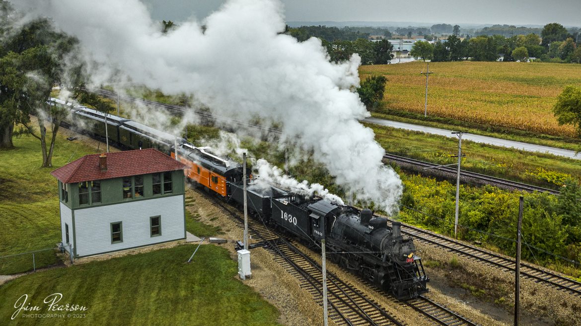 Steam locomotive Frisco 1630 passes Spaulding Tower as it enters the grounds of the Illinois Railway Museum (IRM) on a passenger, during their 70th anniversary weekend in Union, Illinois on September 16th, 2023. 

According to IRM website: At locations where railroads crossed each other at grade (i.e. at the same level), it was usually necessary to install an interlocking tower. This was a manned building, usually two stories tall for better visibility from the tower, where one or more “tower men” would operate the signals and switches governing train traffic through the crossing. 

This interlocking tower was located at Spaulding, a railroad stop on the east side of Elgin, IL, where the Chicago Milwaukee St. Paul & Pacific (the Milwaukee Road) crossed the Elgin Joliet & Eastern. Spaulding Tower was built by the EJ&E around 1891 and was enlarged to its current 12’x30′ footprint in 1909, when the Milwaukee Road double-tracked its main line through Spaulding.

 Around the 1980s the tower was made redundant by the installation of remote interlocking equipment, and it was moved to IRM in several large pieces in August 1988. It has been restored to its 1909 appearance and is used regularly to control train movements on the museum’s demonstration railroad using a restored CTC (Centralized Traffic Control) machine located on the upper floor.

Tech Info: DJI Mavic 3 Classic Drone, RAW, 22mm, f/2.8, 1/400, ISO 130

#trainphotography #railroadphotography #trains #railways #dronephotography #trainphotographer #railroadphotographer #jimpearsonphotography #trains #unionpacific #mavic3classic #drones #trainsfromtheair #trainsfromadrone #IllinoisRailwayMuseum #IllinoisTrains #SteamTrains