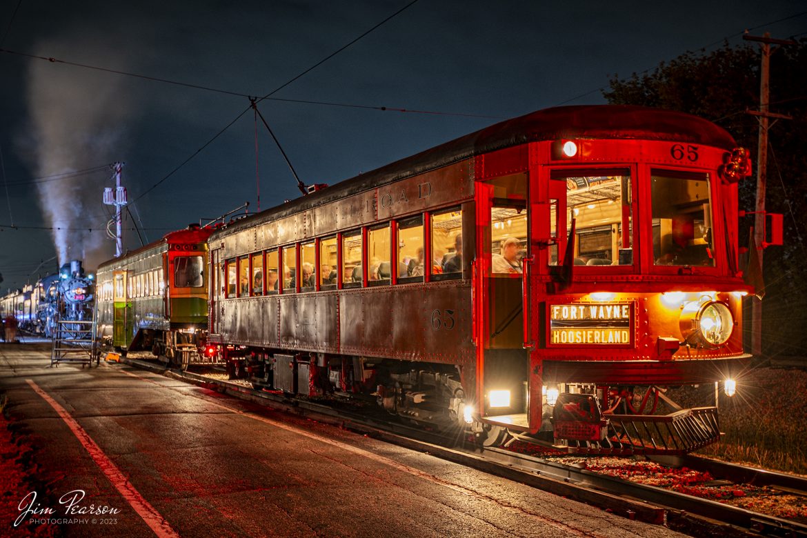 Indiana Railroad 65 Interurban Car sits at the west end of the station platform, ahead of Illinois Terminal interurban coach 101 and Frisco 1530 steam locomotive as it waits to depart the depot at the Illinois Railway Museum (IRM) on the wet and rainy evening of September 16th, 2023, during the IRM 70th Anniversary at Union, Illinois.

According to the IRM website: Indiana Railroad 65 was the first piece of equipment IRM ever acquired, becoming the museums mother car when the museum purchased it for preservation in 1953. When it was new in 1931 it was among the most modern interurban cars in the world, a lightweight coach designed for high-speed operation across the Indiana Railroad interurban network. Car 65 was one of the last interurban cars in use when IRR closed out operations in 1941. Museum volunteers have completely restored car 65 to its appearance while in service in Indiana in the 1930s.

Tech Info: Nikon D800, RAW, Nikon 10-24 @18mm, f/4.5, 30 Seconds, ISO 100.

#trainphotography #railroadphotography #trains #railways #dronephotography #trainphotographer #railroadphotographer #jimpearsonphotography #NikonD800 #IllinoisRailwayMuseum #trainsinbadweather #illinoistrains #interurbancoach #streetcars #trainsatnight