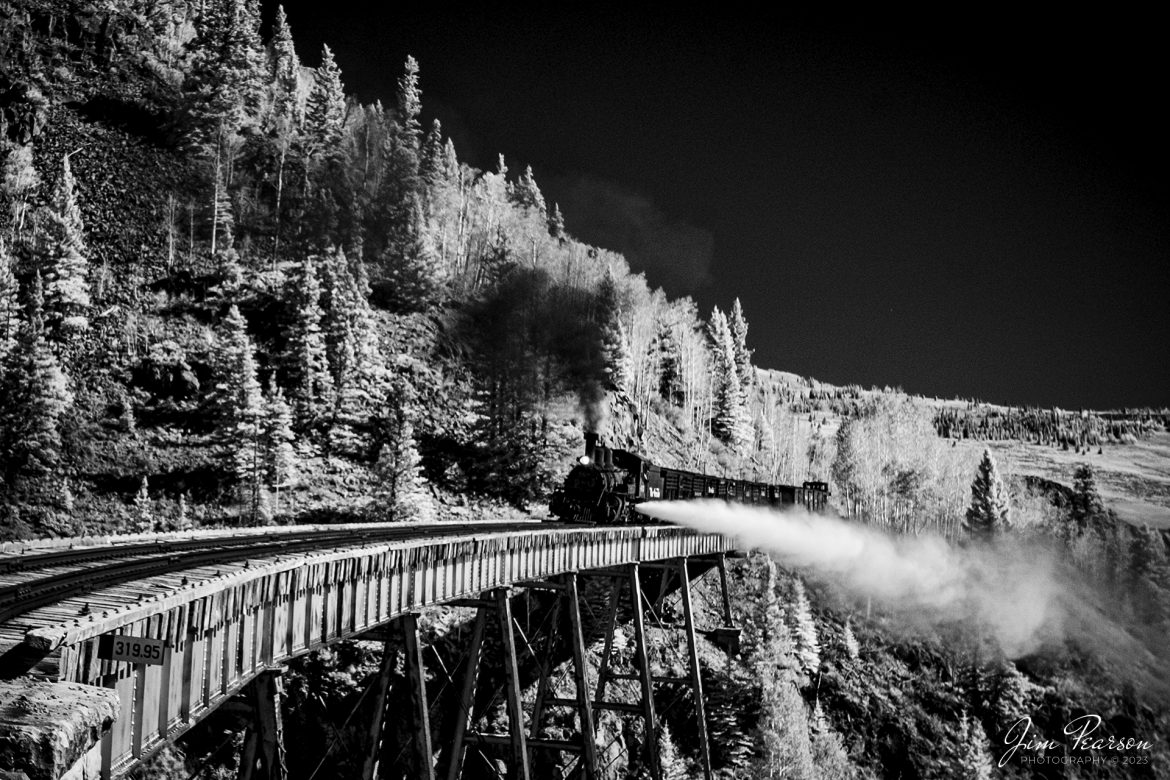 In this weeks Saturday Infrared photo, we find Cumbres & Toltec Scenic Railroad steam locomotive 463 as it conducts a boiler blowdown as it leads a freight over the Cascade Trestle as it heads west, out of Antonito, Colorado, during a photo charter by Dak Dillon Photography on October 19th, 2023.

A blowdown is a way to get minerals and other contaminants out of the locomotive system. Engines want to be on a bridge or trestle because the blow down itself can reach 30+ feet at an angle away from the firebox with live steam. 

According to their website: the Cumbres & Toltec Scenic Railroad is a National Historic Landmark.  At 64-miles in length, it is the longest, the highest and most authentic steam railroad in North America, traveling through some of the most spectacular scenery in the Rocky Mountain West.

Owned by the states of Colorado and New Mexico, the train crosses state borders 11 times, zigzagging along canyon walls, burrowing through two tunnels, and steaming over 137-foot Cascade Trestle. All trains steam along through deep forests of aspens and evergreens, across high plains filled with wildflowers, and through a rocky gorge of remarkable geologic formations. Deer, antelope, elk, fox, eagles and even bear are frequently spotted on this family friendly, off-the grid adventure.

Tech Info: Fuji XT-1, RAW, Converted to 720nm B&W IR, Sigma 24-70 @ 24mm, f/5.6, 1/350, ISO 400.

#trainphotography #railroadphotography #trains #railways #jimpearsonphotography #infraredtrainphotography #infraredphotography #trainphotographer #railroadphotographer #CumbresandToltecScenicRailroad #steamtrain