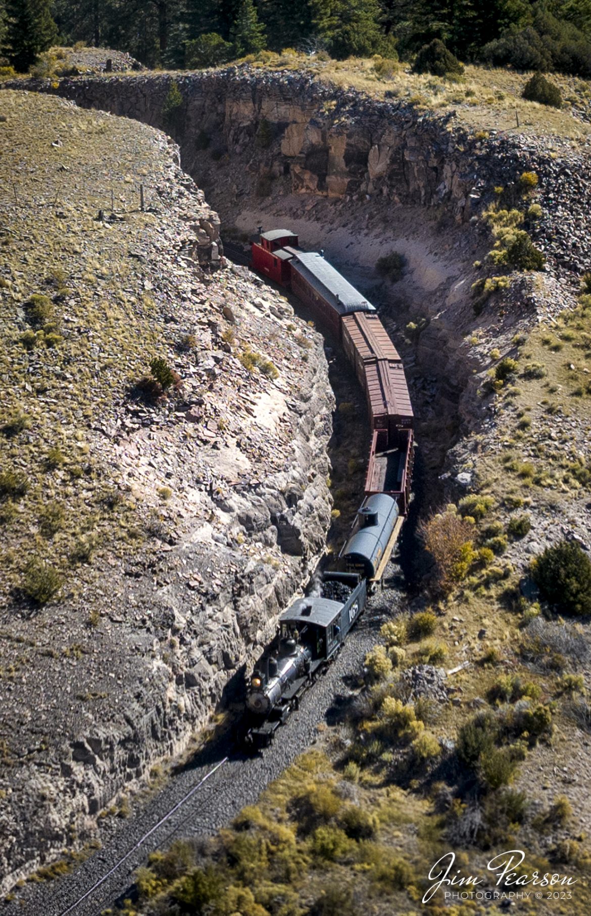 Cumbres & Toltec Scenic Railroad steam locomotive D&RGW 168 as it leads noonday freight through one of the many cuts between Antonito and Osier, Colorado, during a photo charter by Dak Dillon Photography on October 20th, 2023.

According to their website: the Cumbres & Toltec Scenic Railroad is a National Historic Landmark.  At 64-miles in length, it is the longest, the highest and most authentic steam railroad in North America, traveling through some of the most spectacular scenery in the Rocky Mountain West.

Owned by the states of Colorado and New Mexico, the train crosses state borders 11 times, zigzagging along canyon walls, burrowing through two tunnels, and steaming over 137-foot Cascade Trestle. All trains steam along through deep forests of aspens and evergreens, across high plains filled with wildflowers, and through a rocky gorge of remarkable geologic formations. Deer, antelope, elk, fox, eagles and even bear are frequently spotted on this family friendly, off-the grid adventure.

Tech Info: DJI Mavic 3 Classic Drone, RAW, 22mm, f/2.8, 1/2500, ISO 150.

railroad, railroads train, trains, best photo. sold photo, railway, railway, sold train photos, sold train pictures, steam trains, rail transport, railroad engines, pictures of trains, pictures of railways, best train photograph, best photo, photography of trains, steam, train photography, sold picture, best sold picture, Jim Pearson Photography, Cumbres & Toltec Scenic Railroad
