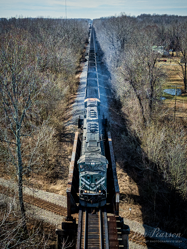 Paducah and Louisville Railway locomotive 4504 leads a Louisville Gas and Electric loaded coal train as it heads north, crossing over the CSX Henderson Subdivision at Monarch, at Madisonville, Kentucky on February 7th, 2024, bound for the power plant outside of Louisville, Ky.

According to Wikipedia: The Paducah & Louisville Railway (reporting mark PAL) is a Class II railroad that operates freight service between Paducah and Louisville, Kentucky. The line is located entirely within the Commonwealth of Kentucky.

The 270-mile (430 km) line was purchased from Illinois Central Gulf Railroad in August 1986. The 223-mile (359 km) main route runs between Paducah and Louisville with branch lines from Paducah to Kevil and Mayfield, Kentucky, and another from Cecilia to Elizabethtown, Kentucky. The PAL interchanges with Burlington Northern Santa Fe (BNSF) and Canadian National (CN), formerly Illinois Central Railroad, in Paducah. In Madisonville, the line interchanges with CSX Transportation (CSXT).

Tech Info: DJI Mavic 3 Classic Drone, RAW, 22mm, f/2.8, 1/2500, ISO 290.

#railroad #railroads #train #trains #bestphoto #railroadengines #picturesoftrains #picturesofrailway #bestphotograph #photographyoftrains #trainphotography #JimPearsonPhotography #PaucahandLouisvillerailway #tending