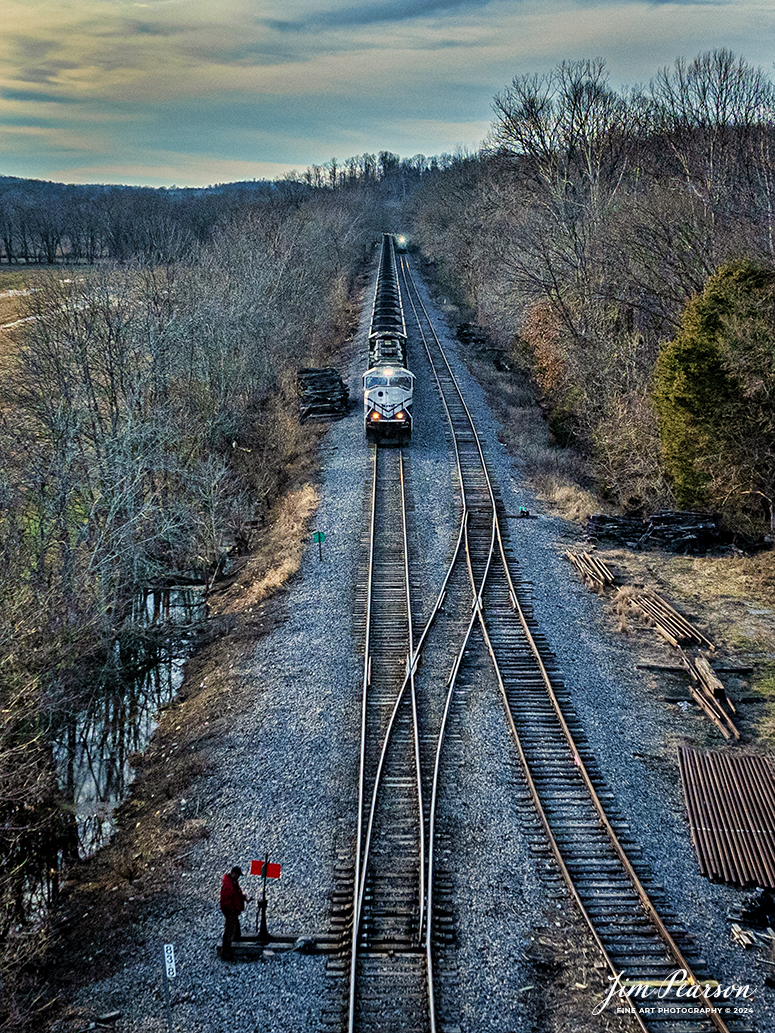 After doing a train swap at Caneyville, Ky the conductor on the northbound Paducah and Louisville (PAL) Louisville Gas and Electric coal train prepares to throw the switch at the north end of the siding, to continue their move north on February 1st, 2024. 

The Louisville crew is taking the loaded train back to their home territory north on the PAL to deliver their load to Louisville Gas and Electric power plant, outside of Louisville, Ky. The Madisonville crew is taking the empty train back south (in the distance) for another load of coal from Warrior Coal Mine.

Tech Info: DJI Mavic 3 Classic Drone, RAW, 22mm, f/2.8, 1/2500, ISO 370.

#trainphotography #railroadphotography #trains #railways #jimpearsonphotography #trainphotographer #railroadphotographer #csxt #dronephoto #trainsfromadrone #paducahandlouisvillerailroad #trending