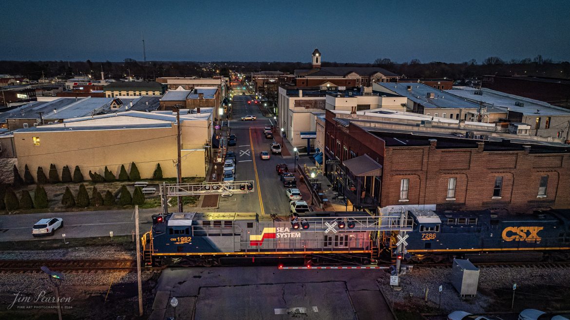 One of the new CSX Heritage series locomotives, the Seaboard System unit 1982, leads on CSX I026 as it heads north at dusk at Madisonville, Ky, on March 2nd, 2024, on the Henderson Subdivision.

I first caught this train at Red River at Adams, TN and it was about 60 miles later here in Madisonville, Ky before I was able to get far enough ahead of it to setup for another shot.

 I had hoped it would show up before the sunset, but alas, it didn't happen. However I'm very pleased with this shot with my drone. I've been using DxO Pure RAW 3 for noise removal and it did a fantastic joh on this shot that was made at ISO 2630!

According to Wikipedia: The Seaboard System Railroad, Inc. (reporting mark SBD) was a US Class I railroad that operated from 1982 to 1986.

Since the late 1960s, Seaboard Coast Line Industries had operated the Seaboard Coast Line and its sister railroads, notably the Louisville & Nashville and Clinchfield, as the “Family Lines System”. In 1980, SCLI merged with the Chessie System to create the holding company CSX Corporation; two years later, CSX merged the Family Lines railroads to create the Seaboard System Railroad.

In 1986, Seaboard renamed itself CSX Transportation, which absorbed the Chessie System’s two major railroads the following year.

Tech Info: DJI Mavic 3 Classic Drone, RAW, 22mm, f/2.8, 1/240, ISO 2630.

#trainphotography #railroadphotography #trains #railways #jimpearsonphotography #trainphotographer #railroadphotographer #csxt #dronephoto #trainsfromadrone #trending #CSXHeritageUnit