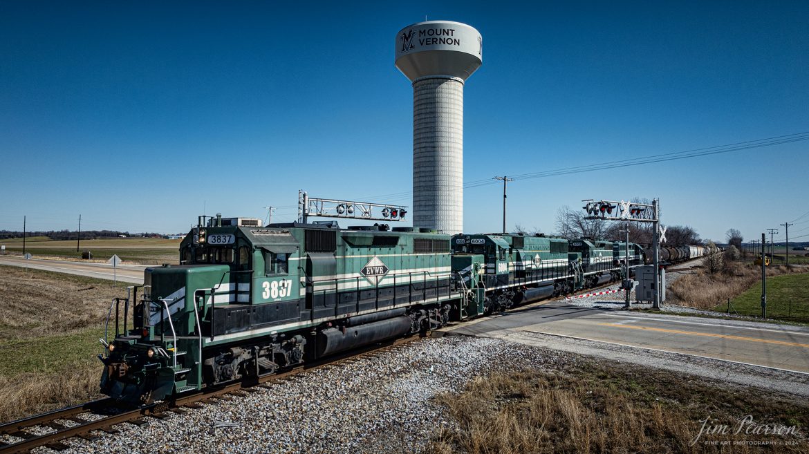 Evansville Western Railway locomotive 3837 leads a daily local north from Evansville, Indiana as it passes over the William Keck Bypass Road crossing at Mount Vernon, Indiana on March 11th, 2024.

According to Wikipedia: The Evansville Western Railway (reporting mark EVWR) is a Class II (as of 2022) regional railroad operating in the southern Illinois and Indiana region. It is one of three regional railroad subsidiaries owned and operated by P&L Transportation.

Founded in August 2005, the railroad commenced its first operations on January 1, 2006, when P&L Transportation, formerly Four Rivers Transportation, the parent company of both the Evansville Western and Paducah & Louisville railroads, leased 124.5 miles (200.4 km) of mainline track, ties and track equipment between CSX's Howell Yard in Evansville, Indiana, and the end-of-track at Okawville, Illinois, from CSX Transportation. 

This line was once part of the Louisville & Nashville's former Saint Louis Subdivision route that previously terminated in the metro-area of East St. Louis, Illinois, before being embargoed and slightly shortened under CSX ownership during the fall of 1993. CSX Transportation retains title to the real estate comprising the right of way on which the railroad operates but has leased it to EVWR for an initial period of 20 years.

Tech Info: DJI Mavic 3 Classic Drone, RAW, 22mm, f/8, 1/1600, ISO 100.

#trainphotography #railroadphotography #trains #railways #jimpearsonphotography #trainphotographer #railroadphotographer #dronephoto #trainsfromadrone #EVWR  #evansvillewesterrailway #trending