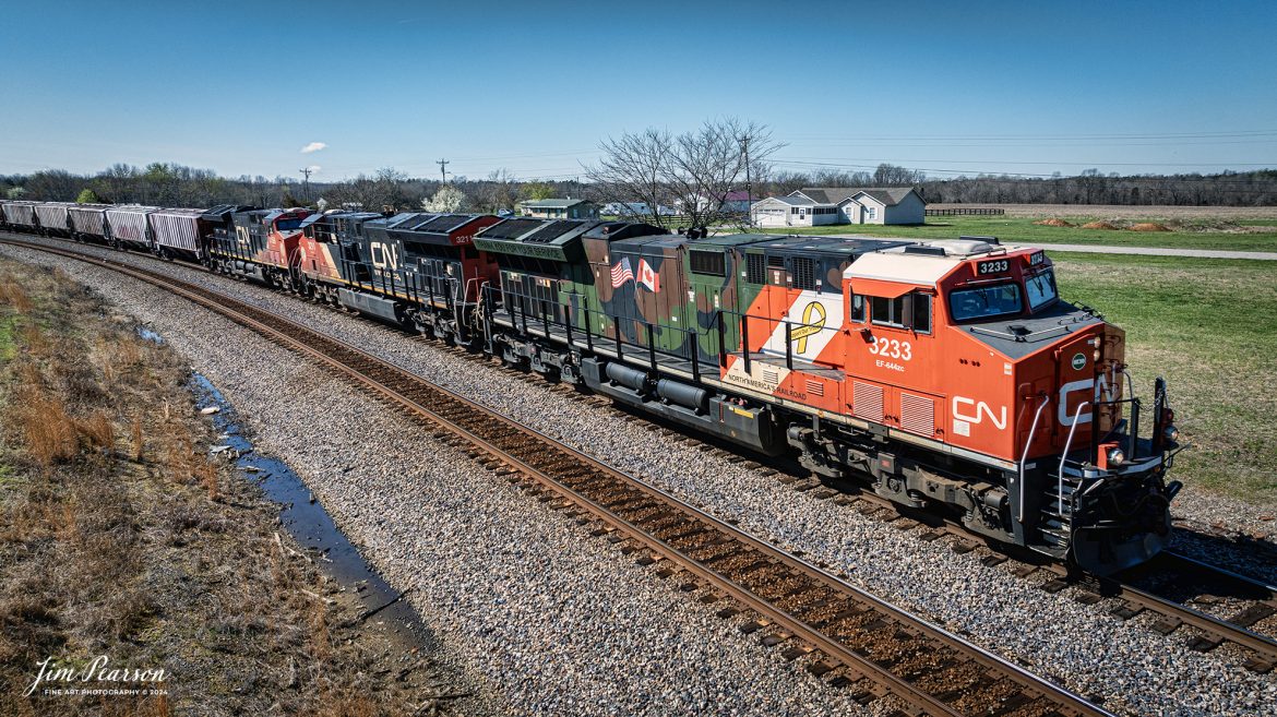 Canadian National (CN) locomotive 3233 (Support our Troops) leads B229-13 as they head north through the curve at the north end of Kelly, Kentucky, on the CSX Henderson Subdivision, March 16th, 2024.

From a CN Press Release: “CN’s two tribute locomotives (CN 3233 & 3015) pay homage to veterans and active military men and women across North America. Their custom design represents the proud footprint we have established across our network and our deep recognition for the veterans who live and work in the communities our trains pass through every day. 

Tech Info: DJI Mavic 3 Classic Drone, RAW, 22mm, f/2.8, 1/2000, ISO 110.

#trainphotography #railroadphotography #trains #railways #jimpearsonphotography #trainphotographer #railroadphotographer #csxt #dronephoto #trainsfromadrone #trending #csxhendersonsubdivision #cnrailway