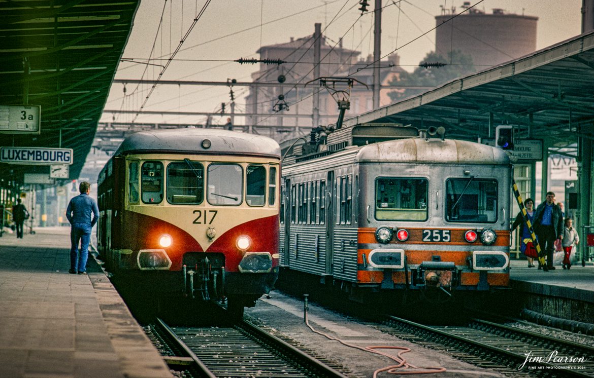 A hazy day shrouds the day as engines 217 and 255 and the rest of their trains sit in the Luxembourg main train station as passengers mill about on the platforms in this 1981 photo where I changed trains on one of my many trips around Europe from 1978-1981 when I lived outside Frankfurt, West Germany.

According to Wikipedia: Luxembourg railway station is the main railway station serving Luxembourg City, in southern Luxembourg. It is operated by Chemins de Fer Luxembourgeois, the state-owned railway company and 80,000 passengers use this station every day.

It is the hub of Luxembourg's domestic railway network, serving as a point of call on all of Luxembourg's railway lines. It also functions as the country's international railway hub, with services to all the surrounding countries: Belgium, France, and Germany. Since June 2007, the LGV Est connects the station to the French TGV network.

#trainphotography #railroadphotography #trains #railways #jimpearsonphotography #trainphotographer #railroadphotographer #Luxembourg #trainstation