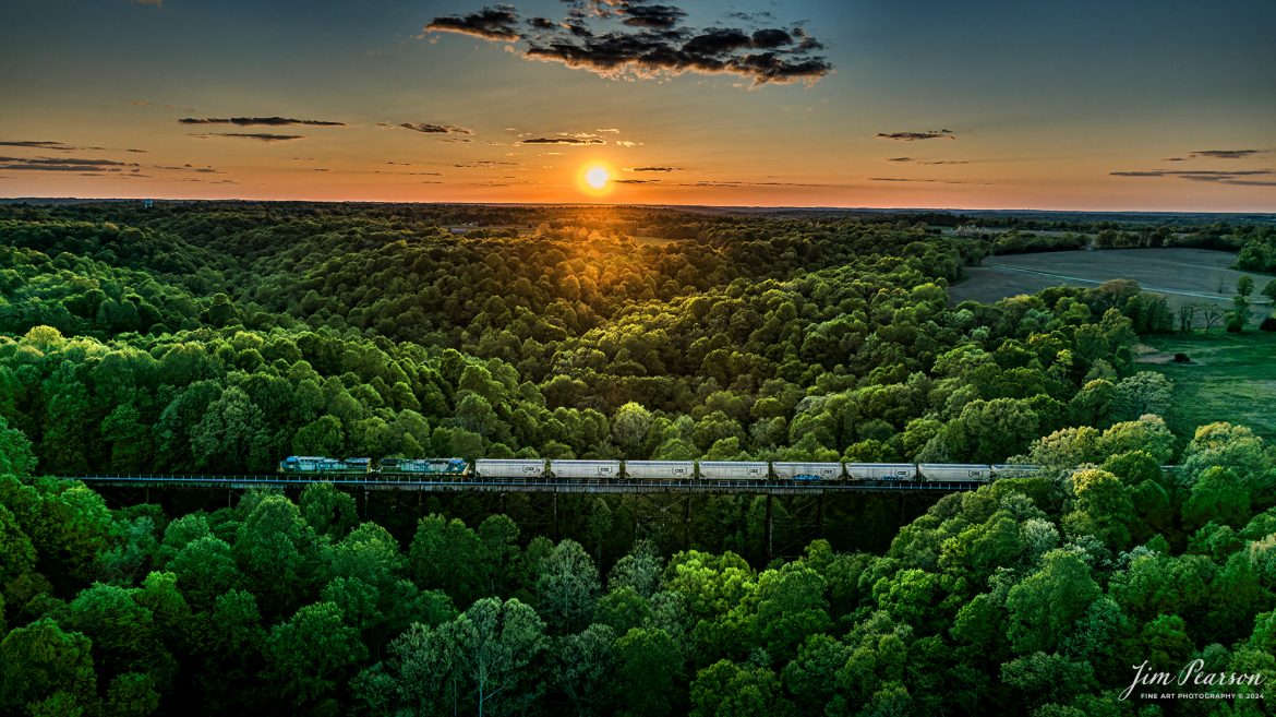 April 21, 2024, As many of you know I've been working on a landscapes photo challenge I've titled 7-Minutes till Sunset, but I fudged on this one and it was shot at 10 minutes till Sunset. - During this challenge have been photographing a landscape daily from the air at 7 minutes till sunset, but today I was planning on shooting Gum Lick Trestle, just north of Kelly, Ky on the CSX Henderson Subdivision on April 21st, 2024.

However, I was blessed with two trains here at sunset today and this is the one closest to my 7 minute mark, which was shot about 3 minutes early, as loaded grain train CSX G413 heads south across it. I really didn't expect a train at this spot at sunset, let along two about 15 minutes apart! The first train was a northbound empty coal train which I'll post later in the week as it was about 30 minutes before sunset.

I threw up a prayer on my way to Gum Lick from my home in Richland letting the good Lord know it'd be nice if I had a train on the trestle at Sunset, I think he provided nicely even though I didn't expect an answer so breathtakingly, as this line sees very few trains at this time of the day through here! You just never know.

Exposure was for the sun and then I brought up the mid-tones and shadows in the RAW file processing.

Tech Info: DJI Mavic 3 Classic Drone, RAW, 22mm, f/2.8, 1/2000, ISO 100.