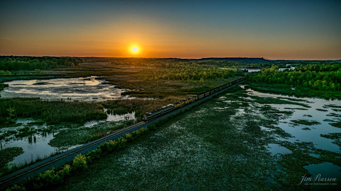 April 24, 2024, As many of you know I've been working on a landscapes photo challenge I've titled 7-Minutes till Sunset, but I fudged on this one again and it was shot at 17 minutes till Sunset, as it was when the train was in the right spot for me.  

During this challenge have been photographing a landscape daily from the air at 7 minutes till sunset, but today I caught a loaded Paducah and Louisville Railway coal train crossing the wetlands after picking up a load of coal at Warrior Coal mine, just outside Madisonville, Ky, on April 24th, 2024.

I have been trying to catch a train here at this spot since I began this challenge on the 15th of April and today was the day!

Exposure was for the sun and then I brought up the mid-tones and shadows in the RAW file processing.

Tech Info: DJI Mavic 3 Classic Drone, RAW, 22mm, f/2.8, 1/5000, ISO 100.