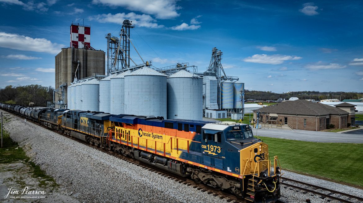 CSXT 1973, Chessie System Heritage Unit, leads CSX M647 as it the Hopkinsville Elevator Company complex at Skyline Drive in Hopkinsville, Ky, as it continues south on the CSX Henderson Subdivision, on March 30th, 2024. The Henderson Subdivision has seen a lot of CSX Heritage units the last week or so and hopefully there’ll be more in the future so I can capture and share them with you! I’ll be posting some videos of these moves in future Saturday Edited Videos so keep an eye out for them!

According to Wikipedia: The three railroads that would make up the Chessie System had been closely related since the 1960s. C&O had acquired controlling interest in B&O in 1962, and the two had jointly controlled WM since 1967.

Chessie System, Inc. was a holding company that owned the Chesapeake and Ohio Railway (C&O), the Baltimore and Ohio Railroad (B&O), the Western Maryland Railway (WM), and Baltimore and Ohio Chicago Terminal Railroad (B&OCT). Trains operated under the Chessie name from 1973 to 1987.

On November 1, 1980, Chessie System merged with Seaboard Coastline Industries to form CSX Corporation. Initially, the three Chessie System railroads continued to operate separately, even after Seaboard’s six Family Lines System railroads were merged into the Seaboard System Railroad on December 29, 1982. That began to change in 1983, when the WM was merged into the B&O. The Chessie image continued to be applied to new and re-painted equipment until July 1, 1986, when CSXT introduced its own paint scheme. In April 1987, the B&O was merged into the C&O. In August 1987, C&O merged into CSX Transportation, a 1986 renaming of the Seaboard System Railroad, and the Chessie System name was retired.

Tech Info: DJI Mavic 3 Classic Drone, RAW, 22mm, f/2.8, 1/1600, ISO 100.

#trainphotography #railroadphotography #trains #railways #jimpearsonphotography #trainphotographer #railroadphotographer #csxt #dronephoto #trainsfromadrone #csx #csxheritageunit #trending