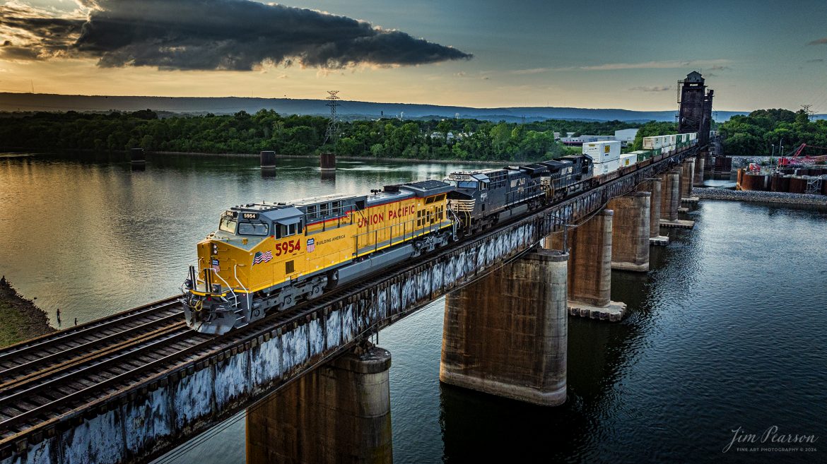 Union Pacific 5954, sporting their new paint scheme, leads a southbound Norfolk Southern Intermodal across the Tennbridge, over the Tennessee River at sunset, on the CNO&TP Third District, at East Chattanooga, TN. 

According to Wikipedia: Tenbridge is a vertical-lift railroad bridge over the Tennessee River in Chattanooga, Tennessee. It has a main span of 310 feet (94 m).

The original span was a swing span with a center pivot that was originally built in ca. 1879/1880. It was replaced by a vertical lift span in 1917, but the lift towers and machinery were not installed until 1920. It remains a very busy crossing on the Cincinnati, New Orleans and Texas Pacific Railway, a major subsidiary of the Norfolk Southern Railway. The bridge carries two mainline tracks across the river.

Tech Info: DJI Mavic 3 Classic Drone, RAW, 24mm, f/2.8, 1/1600, ISO 330.