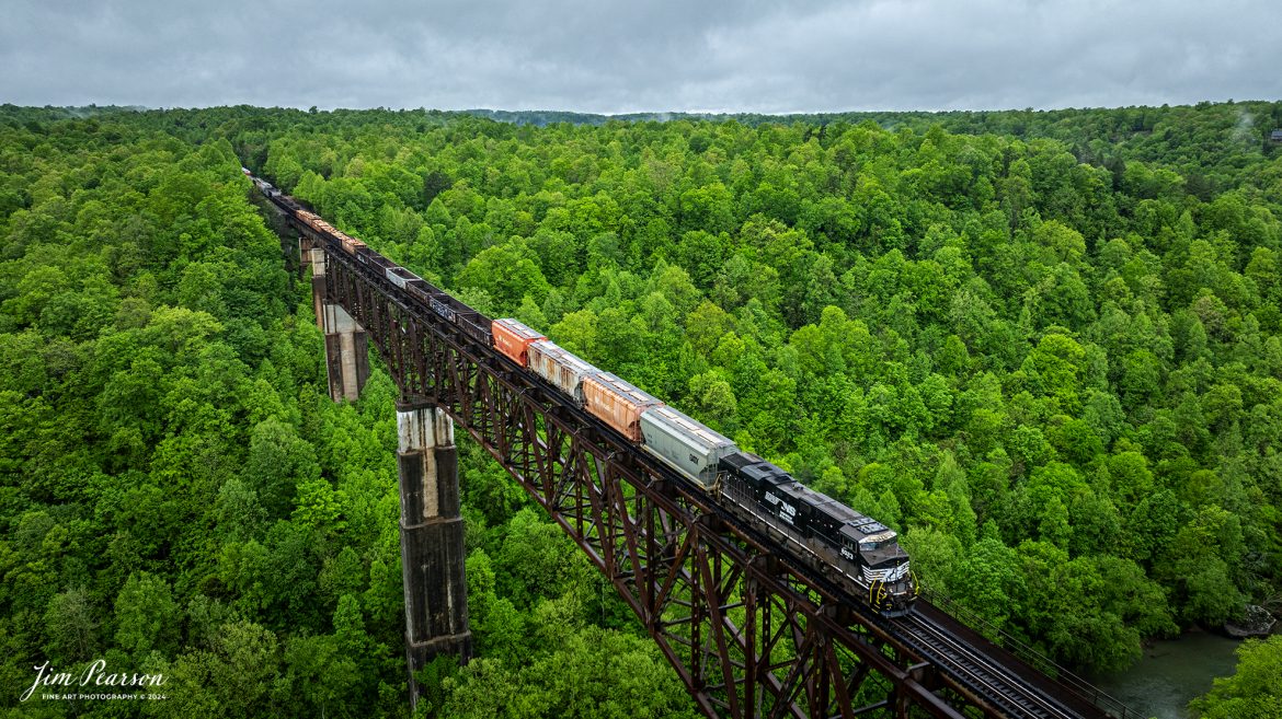 Norfolk Southern 8023 brings up the rear as DPU on NS 167 as they make their way across the New River Bridge under stormy skies as they head southbound on the NS CNO&TP (Rathole) Second District at New River, Tennessee. On April 30th, 2024.  

DPU Stands for Distributed Power Unit, a locomotive set capable of remote-control operation in conjunction with locomotive unites at the train's head end. DPUs are placed in the middle or at the rear of heavy trains (such as coal, or grain) to help climb steep grades.

According to the Historic Bridges website: This bridge is a very large high level deck cantilever truss bridge. It was constructed in 1963 and as such is a late example of its type, but still noteworthy as an uncommon structure type and for its size. Typical of 1960s truss bridges, the bridge still has riveted built-up beams, but v-lacing and lattice are absent in the built-up beams, and truss connections are bolted instead of riveted. It is 1,622.0 Feet (494.4 Meters) long, with 3 Main Span(s) and 6 Approach Span(s) is over 300 feet above the river.

Tech Info: DJI Mavic 3 Classic Drone, RAW, 22mm, f/2.8, 1/240, ISO 150.

#railroad #railroads #train #trains #bestphoto #railroadengines #picturesoftrains #picturesofrailway #bestphotograph #photographyoftrains #trainphotography #JimPearsonPhotography #nscnotpsubdivision #norfolksouthern #trendingphoto #nsnewriverbridge