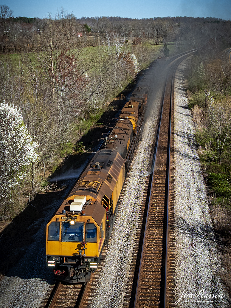 LORAM Railgrinder 305 heads south at Nortonville, Kentucky as they grind their way south on March 24th, 2025, on the CSX Henderson Subdivision. 

According to Wikipedia: A railgrinder (or rail grinder) is a maintenance of way vehicle or train used to restore the profile and remove irregularities from worn tracks to extend its life and to improve the ride of trains using the track. Rail grinders were developed to increase the lifespan of the tracks being serviced for rail corrugation. Rail grinding is a process that is done to stop deformation due to use and friction on railroad tracks by removing deformations and corrosion.

Railroad tracks that experience continual use are more likely to experience corrugation and overall wear. Rail grinders are used to grind the tracks when rail corrugation is present, or before corrugation begins to form on the tracks. Major freight train tracks use rail grinders for track maintenance based on the interval of tonnage, rather than time.

Transit systems and subways in major cities continue to use scheduled rail grinding processes to combat the corrugation common to heavily used tracks. Rail-grinding equipment may be mounted on a single self-propelled vehicle or on a dedicated rail-grinding train which, when used on an extensive network, may include crew quarters. The grinding wheels, of which there may be more than 100, are set at controlled angles to restore the track to its correct profile.

Tech Info: DJI Mavic 3 Classic Drone, RAW, 22mm, f/2.8, 1/2000, ISO 120.

#railroad #railroads #train, #trains #railway #railway #railtransport #railroadengines #picturesoftrains #picturesofrailways #besttrainphotograph #bestphoto #photographyoftrains #bestsoldpicture #JimPearsonPhotography #trainsfromadrone #csxhendersonsubdivision #onecsx #loram #railgrinder