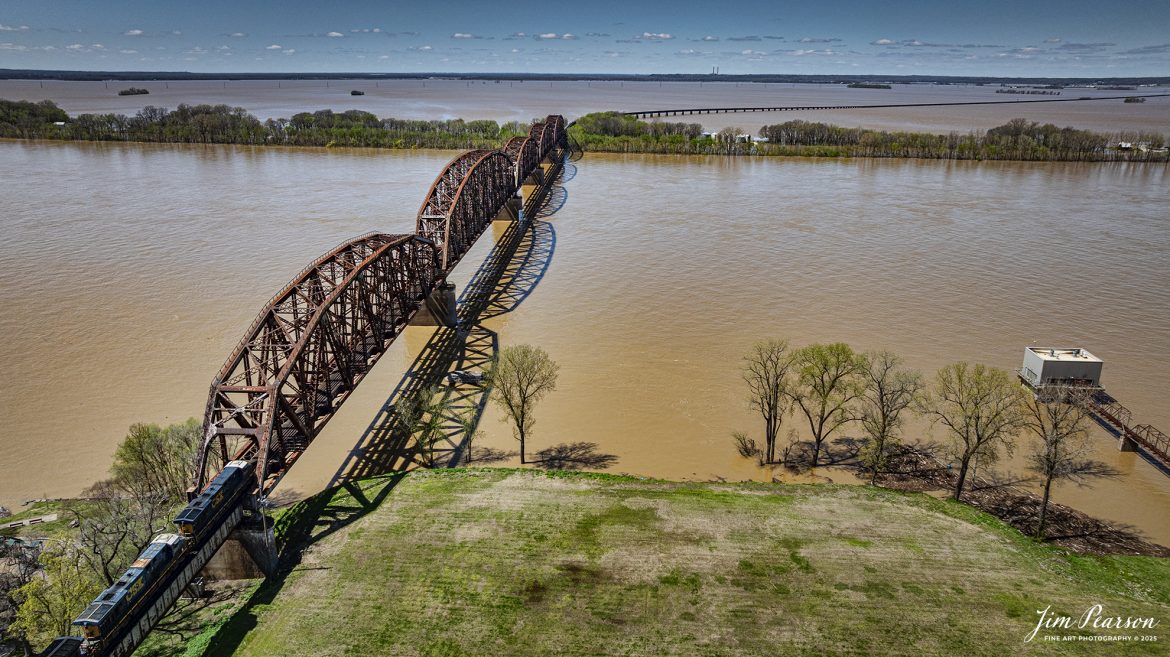 CSX I128 heads onto the south end of the bridge over the flooded Ohio River as it heads north from Henderson, Kentucky on April 8th, 2025, on the CSX Henderson Subdivision.

This area of Kentucky and southern Indiana got record breaking rainfall throughout the region over a three-day period which resulted in major flooding on both sides of the Ohio River. In the distance you can see the farmlands which have been totally covered by the flooding and the ballast deck out of Evansville was close to being covered, but fortunately it didn’t happen.

Tech Info: DJI Mavic 3 Classic Drone, RAW, 22mm, f/2.8, 1/2500, ISO 100.

#railroad #railroads #train, #trains #railway #railway #railtransport #railroadengines #picturesoftrains #picturesofrailways #besttrainphotograph #bestphoto #photographyoftrains #bestsoldpicture #JimPearsonPhotography #trainsfromadrone #csxhendersonsubdivision #onecsx #flooding