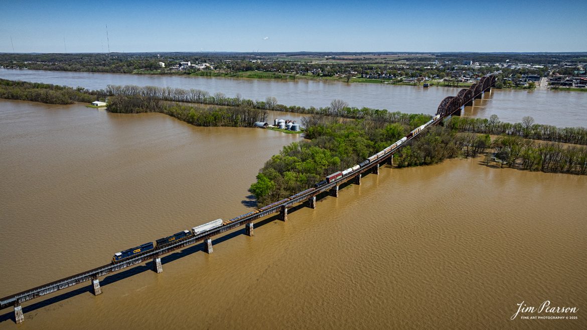 CSX Mixed freight X509, a reroute, heads north over the flooded Ohio River at Henderson, Kentucky on April 8th, 2025, on the CSX Henderson Subdivision as it crosses the flood plain heading into Evansville, Indiana.

This area of Kentucky and southern Indiana got record breaking rainfall throughout the region over a three-day period which resulted in major flooding on both sides of the Ohio River. In the distance you can see the farmlands which have been totally covered by the flooding and the ballast deck out of Evansville was close to being covered, but fortunately it didn’t happen.

Tech Info: DJI Mavic 3 Classic Drone, RAW, 22mm, f/2.8, 1/2000, ISO 100.

#railroad #railroads #train, #trains #railway #railway #railtransport #railroadengines #picturesoftrains #picturesofrailways #besttrainphotograph #bestphoto #photographyoftrains #bestsoldpicture #JimPearsonPhotography #trainsfromadrone #csxhendersonsubdivision #onecsx #flooding