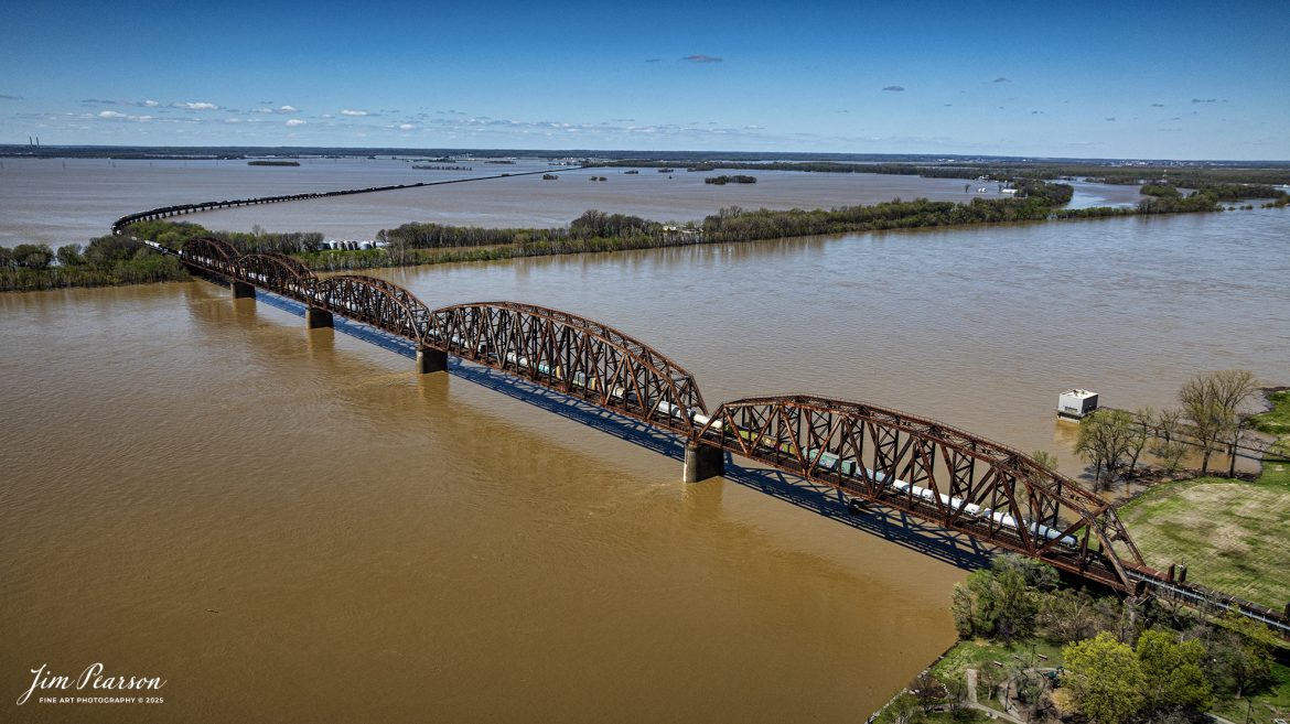 CSX Mixed freight X509, a reroute, heads north over the flooded Ohio River at Henderson, Kentucky on April 8th, 2025, on the CSX Henderson Subdivision as it crosses the flood plain heading into Evansville, Indiana.

This area of Kentucky and southern Indiana got record breaking rainfall throughout the region over a three-day period which resulted in major flooding on both sides of the Ohio River. In the distance you can see the farmlands which have been totally covered by the flooding and the ballast deck out of Evansville was close to being covered, but fortunately it didn’t happen.

Tech Info: DJI Mavic 3 Classic Drone, RAW, 22mm, f/2.8, 1/2000, ISO 100.

#railroad #railroads #train, #trains #railway #railway #railtransport #railroadengines #picturesoftrains #picturesofrailways #besttrainphotograph #bestphoto #photographyoftrains #bestsoldpicture #JimPearsonPhotography #trainsfromadrone #csxhendersonsubdivision #onecsx #flooding