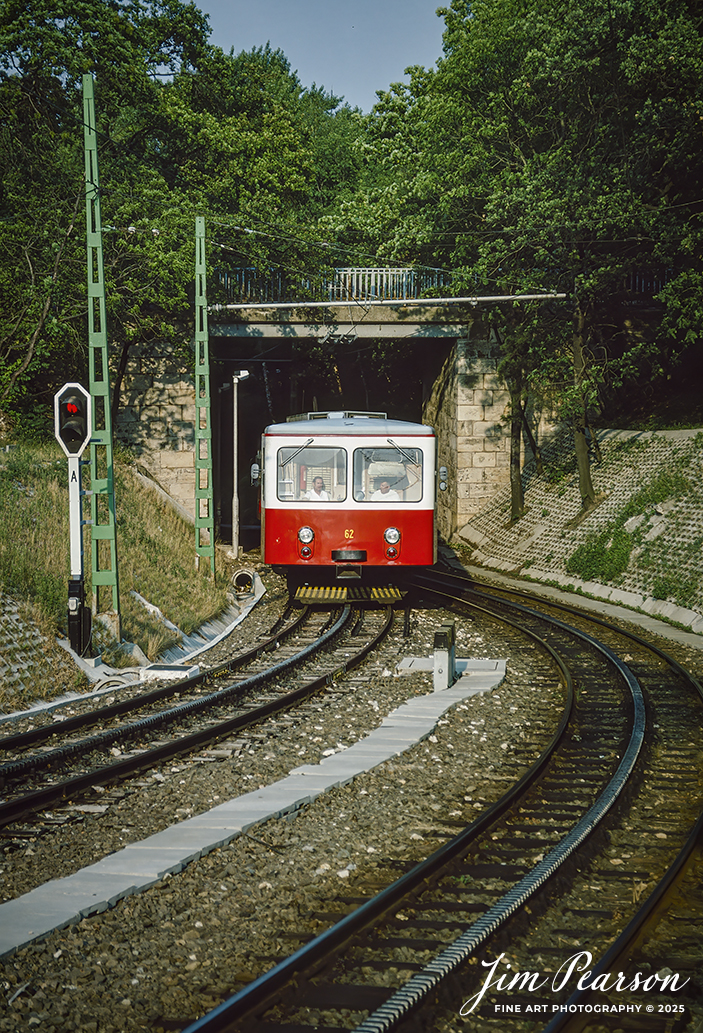 Film Wednesday – 1993 – Today’s slide scan is of a train on the Budapest Cog-wheel Railway, Budapest, Hungary. 

According to Wikipedia: The Budapest Cog-wheel Railway (Hungarian: budapesti fogaskerekű vasút [ˈbudɒpɛʃti ˈfoɡɒʃkɛrɛkyː ˈvɒʃuːt]) is a rack railway in the Buda part of the Hungarian capital city of Budapest. It connects a lower terminus at Városmajor [hu], two tram stops away from the Széll Kálmán tér transport interchange, with an upper terminus at Széchenyihegy [hu]. The line is integrated into the city's public transport system as tram line number 60, is 3.7 kilometres (2.3 mi) in length, and was opened in 1874.

The railway is operated by BKV, who also operate the city's tram and metro lines. It runs throughout the year between the hours of 0500 and 2300. As a fully integrated part of Budapest's public transport system, standard tickets and passes can be used.

The Városmajor terminus is adjacent to the Budapest tram stop of the same name, whilst the Széchenyihegy terminus is a 250-metre (820 ft) walk from the similarly named terminus of the Budapest Children's Railway.

Tech Info: Camera, Nikon F3, Ektachrome Slide Film, no other data recorded, Scanned with an PlusTek 82001i Film Scanner.

#slidescan #filmphotography #trains #railroads #jimpearsonphotography #FilmPhotography