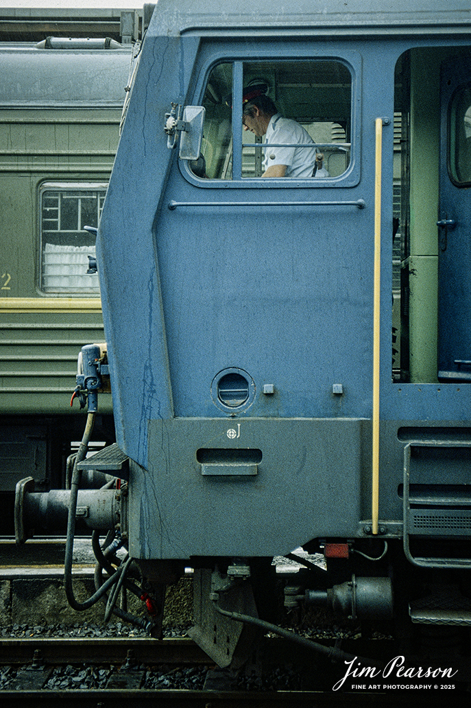 Film Wednesday – 1993 – Today’s slide scans are from time that I spent at the Budapest-Nyugati Railway Station, in Budapest, Hungry. This shot is of a engineer  filling out his paperwork, prior to his train departing.

According to Wikipedia, Budapest Nyugati station (Hungarian: Nyugati pályaudvar, pronounced [ˈɲuɡɒti ˈpaːjɒudvɒr]; lit. 'western railway station'), generally referred to simply as Nyugati, is one of the three main railway terminals in Budapest, Hungary. The station is on the Pest side of Budapest, accessible by the 4 and 6 tramline and the M3 metro line.

The station was designed by Auguste de Serres and was built by the Eiffel Company. It was opened on 28 October 1877. It replaced another station, which was the terminus of Hungary's first railway line, the Pest–Vác line (constructed in 1846). This building was demolished to construct the Grand Boulevard.

The station got its name from the adjacent Western Square ('Nyugati tér'), a major intersection where Teréz körút (Theresia Boulevard), Szent István körút (Saint Stephen Boulevard), Váci út (Váci Avenue), and Bajcsy-Zsilinszky út (Bajcsy-Zsilinszky Avenue) converge. The square also serves as a transport hub with several bus routes, tram routes 4 and 6, and a station on M3 of the Budapest Metro.

Beside the terminal and partially above its open area there is the WestEnd City Center shopping mall. Inside the station is a McDonald's restaurant which has been described as the "most elegant" McDonald's in the world.

The music video for Gwen Stefani's 2008 single Early Winter was partly shot at Nyugati. Starting in May 2016 the key scenes of the movie Terminal were shot over 27 nights.

Tech Info: Camera, Nikon F3, Ektachrome Slide Film, no other data recorded, Scanned with an PlusTek 82001i Film Scanner.

#slidescan #filmphotography #trains #railroads #jimpearsonphotography #FilmPhotography