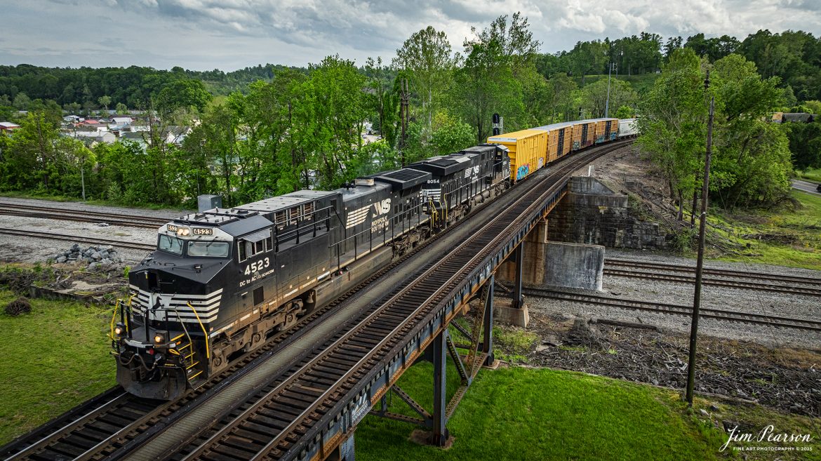 A Norfolk Southern mixed freight approaches the old N&W Bridge over the Ohio River on the Kenova District, crossing over the CSX Kankakee Subdivision as it heads westbound at Kenova, on May 2nd, 2025.

According to Wikipedia, the bridge was first completed in 1892 with a single track, but its piers were sized for future widening. The expansion to two tracks was undertaken in 1913 by Norfolk and Western, the predecessor railway of the current owner, Norfolk Southern. The railroad added new trusses around the existing structure and expanded the piers. Rail traffic continued throughout construction, and the new tracks opened on June 9, 1913.

Tech Info: DJI Mavic 3 Classic Drone, RAW, 24mm, f/6.3, 1/2000, ISO 330.

#railroad #railroads #train, #trains #railway #railway #railtransport #railroadengines #picturesoftrains #picturesofrailways #besttrainphotograph #bestphoto #photographyoftrains #bestsoldpicture #JimPearsonPhotography #trainsfromtheair #trainsfromadrone #norfolksouthern