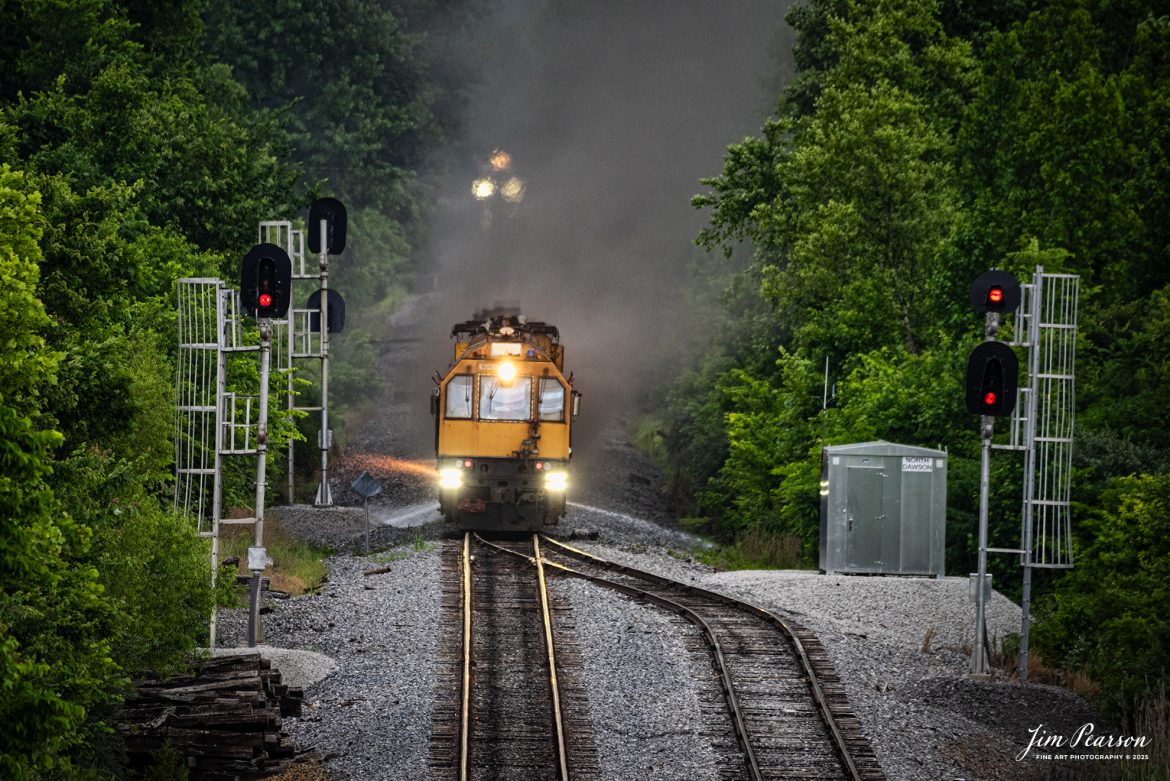 LORAM Railgrinder 403 (long grinder) heads south through the switch at the north end of the siding in Dawson Springs, Kentucky, as it works their on the Paducah and Louisville Railway, on June 5th, 2025.

The lights in the background are from the RG56, which is the short grinder that grinds switches and crossings.

According to Wikipedia: A rail grinder (or rail grinder) is a maintenance of way vehicle or train used to restore the profile and remove irregularities from worn tracks to extend its life and to improve the ride of trains using the track.

Tech Info: Nikon D810, RAW, Sigma 150-600 @ 600mm, f/6.3, 1/1600, ISO 640.

#railroad #railroads #train, #trains #railway #railway #steamtrains #railtransport #railroadengines #picturesoftrains #picturesofrailways #besttrainphotograph #bestphoto #photographyoftrains #bestsoldpicture #JimPearsonPhotography #Brightline #passengertrains #trainsfromtheair #trainsfromadrone #loram