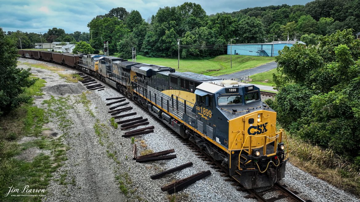 CSX empty coal train E002, with CSX Pere Marquette Heritage Unit 1899 leading, takes the cutoff at Mortons Gap, Ky on August 4th, 2025.

According to a CSX Press Release: May 1, 2024 – CSX has introduced the latest addition in its heritage locomotive series, paying homage to the rich history of the Pere Marquette Railroad. This new unit showcases the Pere Marquette’s legacy, dating back to its inception on November 1, 1899.

The Pere Marquette Railroad, operating in the Great Lakes region of the United States and parts of southern Ontario, Canada, derived its name from Jacques Marquette, a notable French Jesuit missionary credited with founding Michigan’s first European settlement in Sault Ste Marie. After years of operation, the company merged with the Chesapeake and Ohio Railway (C&O) on June 6, 1947, eventually becoming part of the renowned CSX network.

The design of the Pere Marquette heritage locomotive was meticulously crafted by employees at the CSX Waycross Locomotive Shop. According to CSX Carman Painter Eric Lee, “We had to measure each stripe precisely and position the words just right to ensure it captured the look of the original design. It took us about four days just to lay out the stripes before we could begin painting.”

A fascinating tidbit related to the history of Pere Marquette is its cameo in the 2004 film “The Polar Express.” The steam locomotive Pere Marquette 1225 served as the inspiration for the train depicted in the movie, with audio recordings of the actual locomotive in operation featured in the film. Interestingly, the locomotive had been donated to Michigan State University and was exhibited near the university’s football stadium. The author of “The Polar Express” book drew inspiration from seeing this locomotive on display during childhood, solidifying its place in popular culture.

Tech Info: Video Frame Grab from 4K DJI Mavic 3 Classic Drone, RAW, 22mm, f/2.8, 1/400, ISO 100.

#railroad #railroads #train, #trains #railway #railway #steamtrains #railtransport #railroadengines #picturesoftrains #picturesofrailways #besttrainphotograph #bestphoto #photographyoftrains #bestsoldpicture #JimPearsonPhotography #trainsfromtheair #trainsfromadrone #paducahandlouisvillerailway #onecsx #csx