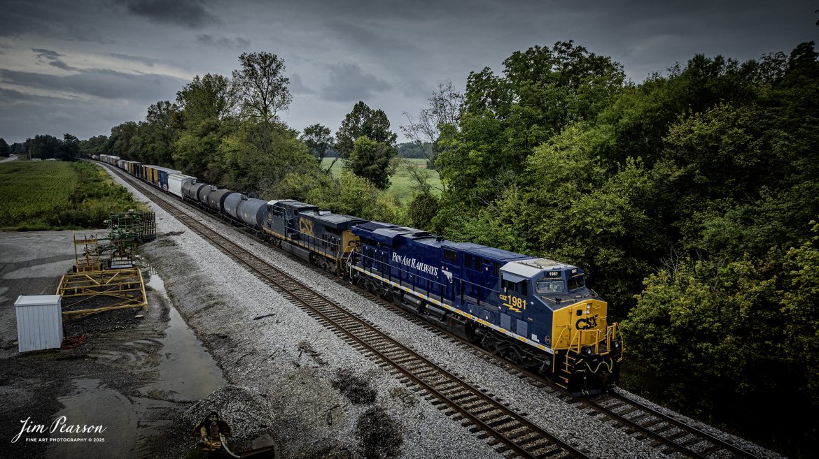 CSXT 1981 Pan Am Railways Heritage Unit leads northbound M512 as they wait on the main for southbound I129 to take the siding at Slaughters, Kentucky, on September 25th, 2025, on the CSX Henderson Subdivision.

According to a CSXT Press Release: November 25, 2024 – CSX has unveiled locomotive No. 1981, the final installment in its series of heritage locomotives, honoring Pan Am Railways. The unit is the 21st and final creation by the Waycross Paint Shop to celebrate the predecessor railroads that form today’s CSX network.

Pan Am Railways, formerly known as Guilford Transportation, was established in 1981 and operated across northern New England, spanning from Maine to New York. It joined the CSX family in 2022 following a purchase agreement.

The heritage series required extra care and precision, according to CSX carman painter Albert Bussey. “It’s always special working on the heritage units,” Bussey said. “Like always, we try to take a little bit of extra care and time in order to do these perfectly.”

All 21 heritage units are not just displays of craftsmanship but active locomotives performing daily duties throughout CSX’s 26-state rail network. The dedication behind their creation reflects the artistry of the team at the Waycross Paint Shop.

The completion of locomotive No. 1981 stands as a tribute to the history of Pan Am Railways and the pride shared by CSX employees. As CSX approaches its 200th anniversary in 2027, these heritage locomotives symbolize the company’s enduring legacy and its dedication to innovation and service.

Tech Info: DJI Mavic 3 Classic Drone, RAW, 22mm, f/2.8, 1/1000, ISO 170

#railroad #railroads #train, #trains #railway #railway #railtransport #railroadengines #picturesoftrains #picturesofrailways #besttrainphotograph #bestphoto #photographyoftrains #bestsoldpicture #JimPearsonPhotography #trainsfromtheair #trainsfromadrone #onecsx #csx