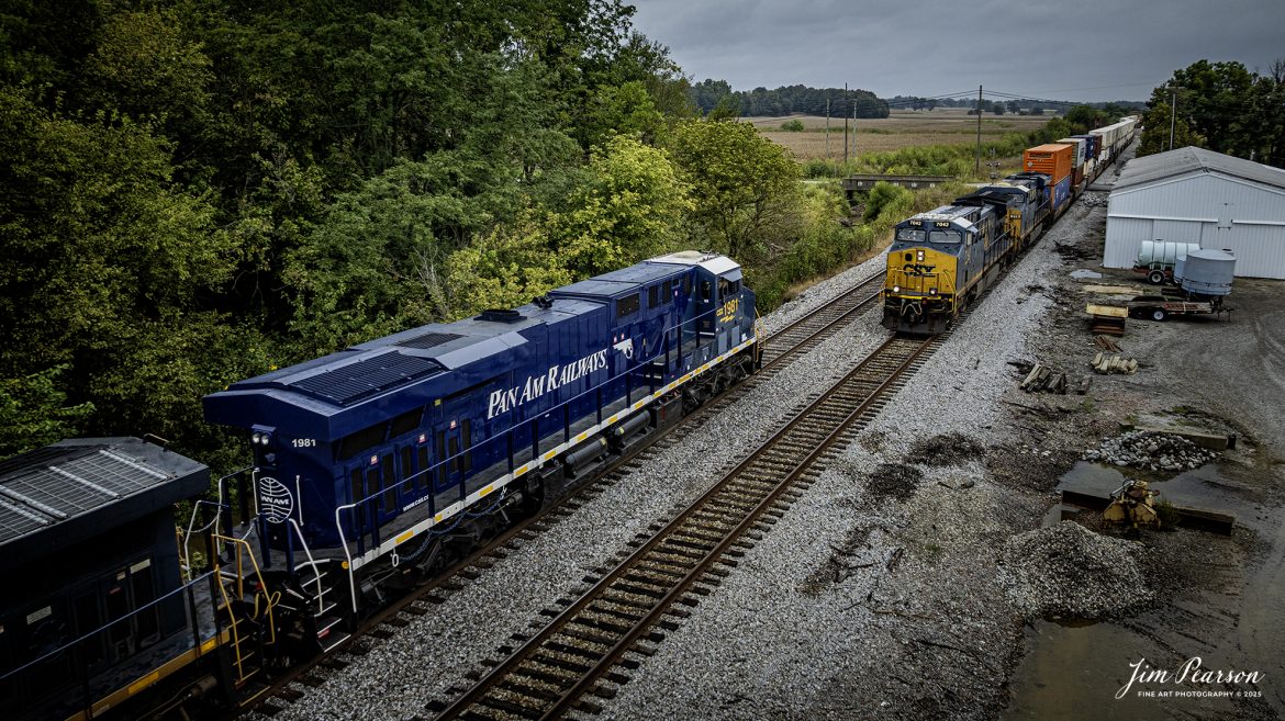 CSXT 1981 Pan Am Railways Heritage Unit leads northbound M512 as they wait on the main for southbound I129 to take the siding at Slaughters, Kentucky, on September 25th, 2025, on the CSX Henderson Subdivision.

According to a CSXT Press Release: November 25, 2024 – CSX has unveiled locomotive No. 1981, the final installment in its series of heritage locomotives, honoring Pan Am Railways. The unit is the 21st and final creation by the Waycross Paint Shop to celebrate the predecessor railroads that form today’s CSX network.

Pan Am Railways, formerly known as Guilford Transportation, was established in 1981 and operated across northern New England, spanning from Maine to New York. It joined the CSX family in 2022 following a purchase agreement.

The heritage series required extra care and precision, according to CSX carman painter Albert Bussey. “It’s always special working on the heritage units,” Bussey said. “Like always, we try to take a little bit of extra care and time in order to do these perfectly.”

All 21 heritage units are not just displays of craftsmanship but active locomotives performing daily duties throughout CSX’s 26-state rail network. The dedication behind their creation reflects the artistry of the team at the Waycross Paint Shop.

The completion of locomotive No. 1981 stands as a tribute to the history of Pan Am Railways and the pride shared by CSX employees. As CSX approaches its 200th anniversary in 2027, these heritage locomotives symbolize the company’s enduring legacy and its dedication to innovation and service.

Tech Info: DJI Mavic 3 Classic Drone, RAW, 22mm, f/2.8, 1/500, ISO 120

#railroad #railroads #train, #trains #railway #railway #railtransport #railroadengines #picturesoftrains #picturesofrailways #besttrainphotograph #bestphoto #photographyoftrains #bestsoldpicture #JimPearsonPhotography #trainsfromtheair #trainsfromadrone #onecsx #csx