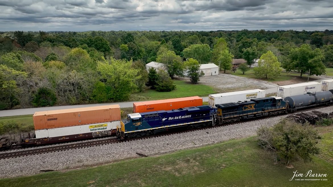 CSXT 1981 Pan Am Railways Heritage Unit leads M512 as they wait for SB I025 to pass them via the siding at Kelly, Kentucky, on September 24th, 2025, on the CSX Henderson Subdivision.

According to a CSXT Press Release: November 25, 2024 – CSX has unveiled locomotive No. 1981, the final installment in its series of heritage locomotives, honoring Pan Am Railways. The unit is the 21st and final creation by the Waycross Paint Shop to celebrate the predecessor railroads that form today’s CSX network.

Pan Am Railways, formerly known as Guilford Transportation, was established in 1981 and operated across northern New England, spanning from Maine to New York. It joined the CSX family in 2022 following a purchase agreement.

The heritage series required extra care and precision, according to CSX carman painter Albert Bussey. “It’s always special working on the heritage units,” Bussey said. “Like always, we try to take a little bit of extra care and time in order to do these perfectly.”

All 21 heritage units are not just displays of craftsmanship but active locomotives performing daily duties throughout CSX’s 26-state rail network. The dedication behind their creation reflects the artistry of the team at the Waycross Paint Shop.

The completion of locomotive No. 1981 stands as a tribute to the history of Pan Am Railways and the pride shared by CSX employees. As CSX approaches its 200th anniversary in 2027, these heritage locomotives symbolize the company’s enduring legacy and its dedication to innovation and service.

Tech Info: 4K Frame Grab from a DJI Mavic 3 Classic Drone, RAW, 22mm, f/2.8.

#railroad #railroads #train, #trains #railway #railway #steamtrains #railtransport #railroadengines #picturesoftrains #picturesofrailways #besttrainphotograph #bestphoto #photographyoftrains #bestsoldpicture #JimPearsonPhotography #trainsfromtheair #trainsfromadrone #onecsx #csx