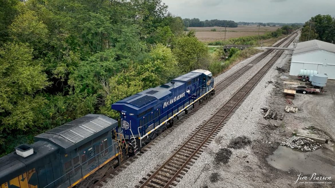 CSXT 1981 Pan Am Railways Heritage Unit leads M512 as they head north from Slaughters, Kentucky, on September 24th, 2025, on the CSX Henderson Subdivision.

According to a CSXT Press Release: November 25, 2024 – CSX has unveiled locomotive No. 1981, the final installment in its series of heritage locomotives, honoring Pan Am Railways. The unit is the 21st and final creation by the Waycross Paint Shop to celebrate the predecessor railroads that form today’s CSX network.

Pan Am Railways, formerly known as Guilford Transportation, was established in 1981 and operated across northern New England, spanning from Maine to New York. It joined the CSX family in 2022 following a purchase agreement.

The heritage series required extra care and precision, according to CSX carman painter Albert Bussey. “It’s always special working on the heritage units,” Bussey said. “Like always, we try to take a little bit of extra care and time in order to do these perfectly.”

All 21 heritage units are not just displays of craftsmanship but active locomotives performing daily duties throughout CSX’s 26-state rail network. The dedication behind their creation reflects the artistry of the team at the Waycross Paint Shop.

The completion of locomotive No. 1981 stands as a tribute to the history of Pan Am Railways and the pride shared by CSX employees. As CSX approaches its 200th anniversary in 2027, these heritage locomotives symbolize the company’s enduring legacy and its dedication to innovation and service.

Tech Info: 4K Frame Grab from a DJI Mavic 3 Classic Drone, RAW, 22mm, f/2.8.

#railroad #railroads #train, #trains #railway #railway #steamtrains #railtransport #railroadengines #picturesoftrains #picturesofrailways #besttrainphotograph #bestphoto #photographyoftrains #bestsoldpicture #JimPearsonPhotography #trainsfromtheair #trainsfromadrone #onecsx #csx