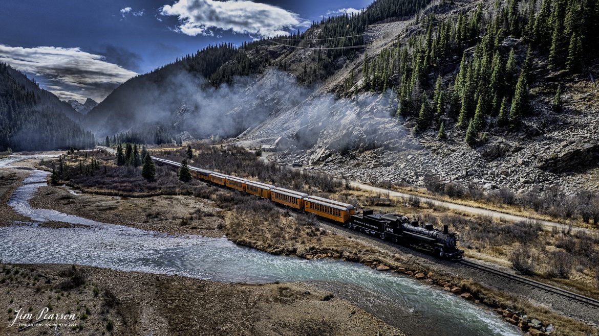 Durango and Silverton Narrow Gauge Railroad locomotive 482 leads the daily passenger train as it runs along the Animas River on the way to Silverton, Colorado on October 22nd. 2025.

D&SNG No. 482 is a K-36 class 2-8-2 "Mikado" type narrow gauge steam locomotive. It was originally built by the Baldwin Locomotive Works in 1925 for the Denver & Rio Grande Western Railroad (D&RGW) and is now preserved as a permanent resident of the Durango & Silverton Narrow Gauge Railroad (D&SNG) in Durango, CO.

The Durango and Silverton Narrow Gauge Railroad, often abbreviated as the D&SNG, is a 3 ft (914 mm) narrow-gauge heritage railroad that operates on 45.2 miles (72.7 km) of track between Durango and Silverton, in the U.S. state of Colorado. The railway is a federally designated National Historic Landmark and was also designated by the American Society of Civil Engineers as a National Historic Civil Engineering Landmark in 1968.

The route was originally opened in 1882 by the Denver and Rio Grande Railroad (D&RG) to transport silver and gold ore mined from the San Juan Mountains. The line was the "San Juan" extension of the D&RG 3 ft (914 mm) narrow-gauge line from Antonito, Colorado, to Durango. The last train to operate into Durango from the east was on December 6, 1968.

The line from Durango to Silverton has run continuously since 1881, although it is now a tourist and heritage line hauling passengers, and is one of the few places in the US which has seen continuous use of steam locomotives.

Tech Info: DJI Air 2S Drone, RAW, 22mm, f/2.8, 1/2500, ISO 110.

#trains #railway #JimPearsonPhotography #trainsfromadrone #steamtrains #D&SNG